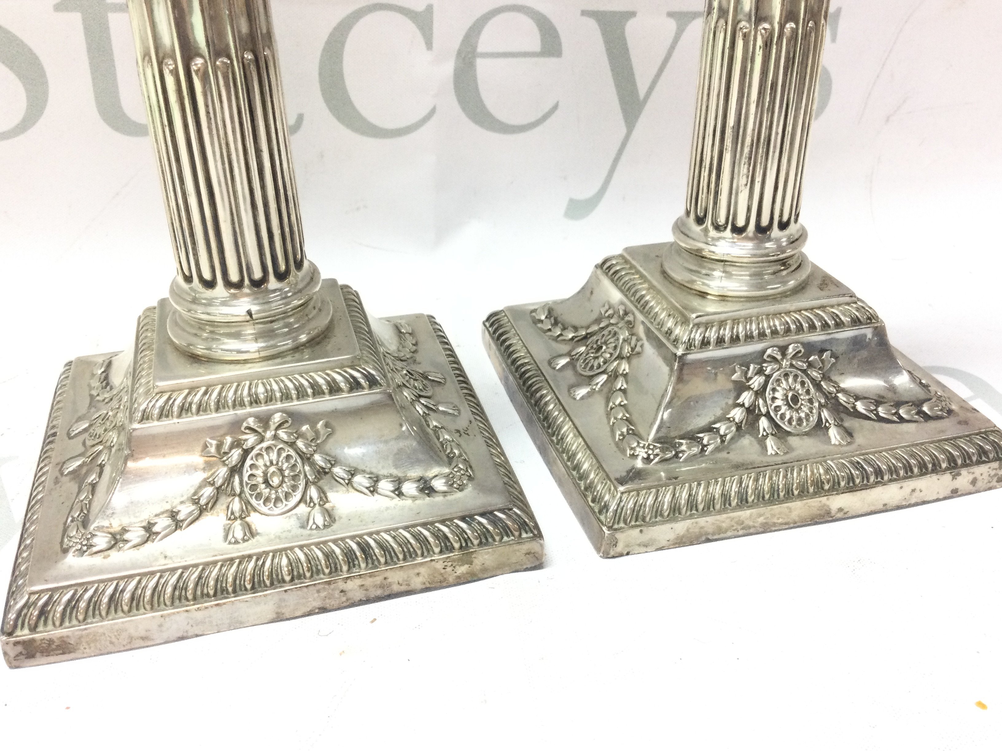 A pair of silver hallmarked corinthian column Candlesticks ,23cm tall.postage category B