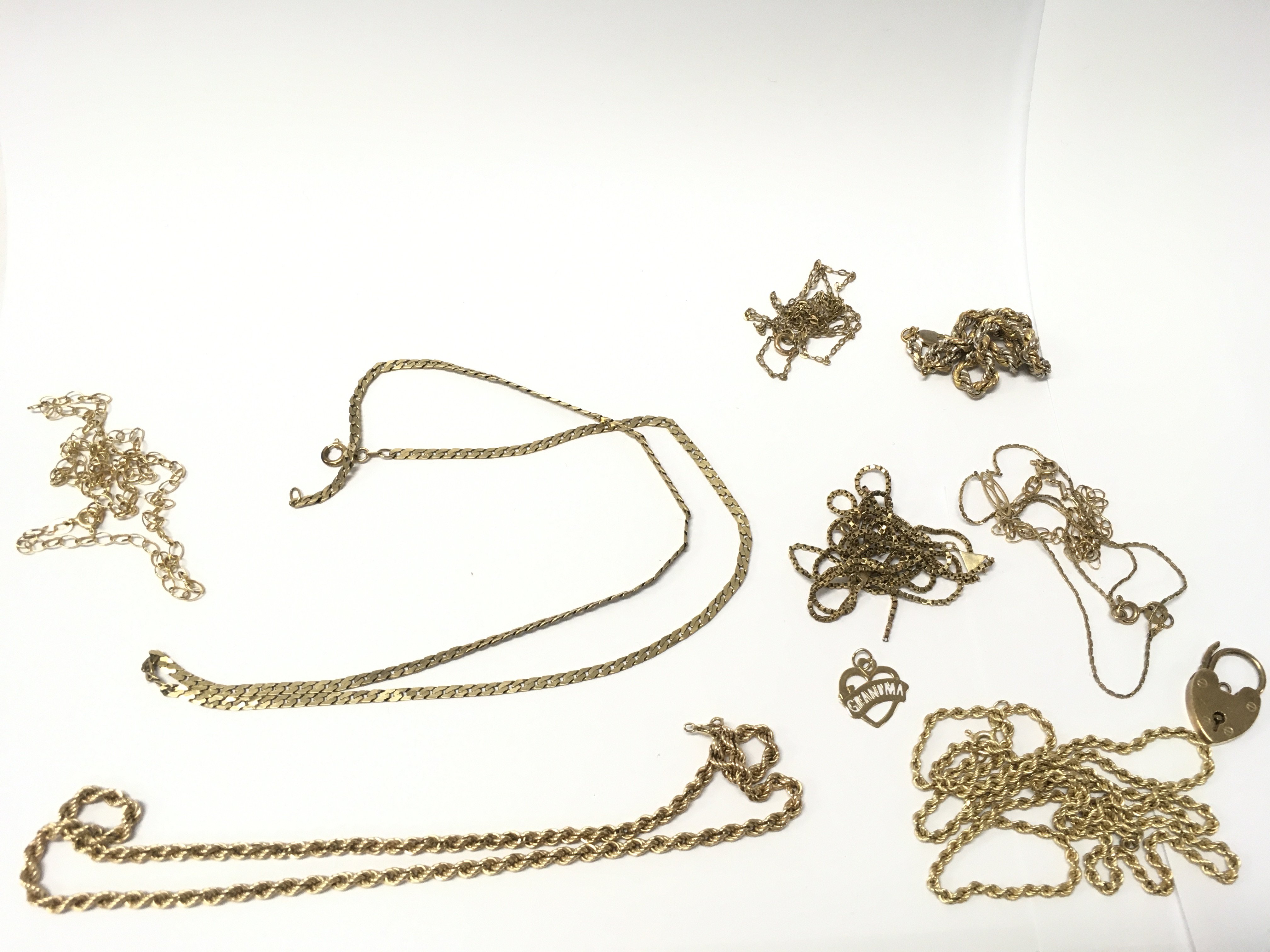 A collection of 9ct gold chains and two pendants. 32g total weight. Postage category A