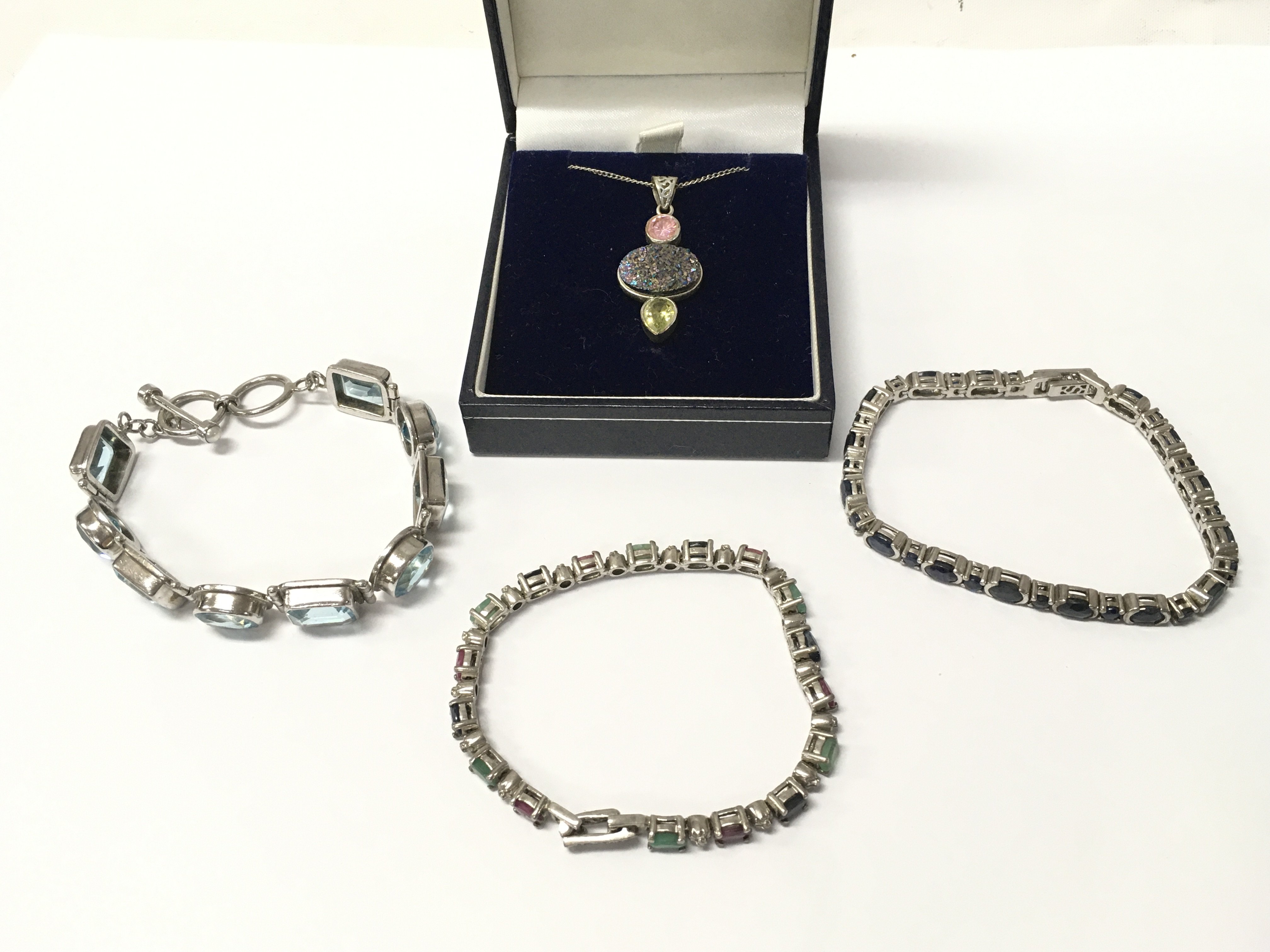 Three silver bracelets and a necklace with an unusual gemstone set pendant . Postage cat a