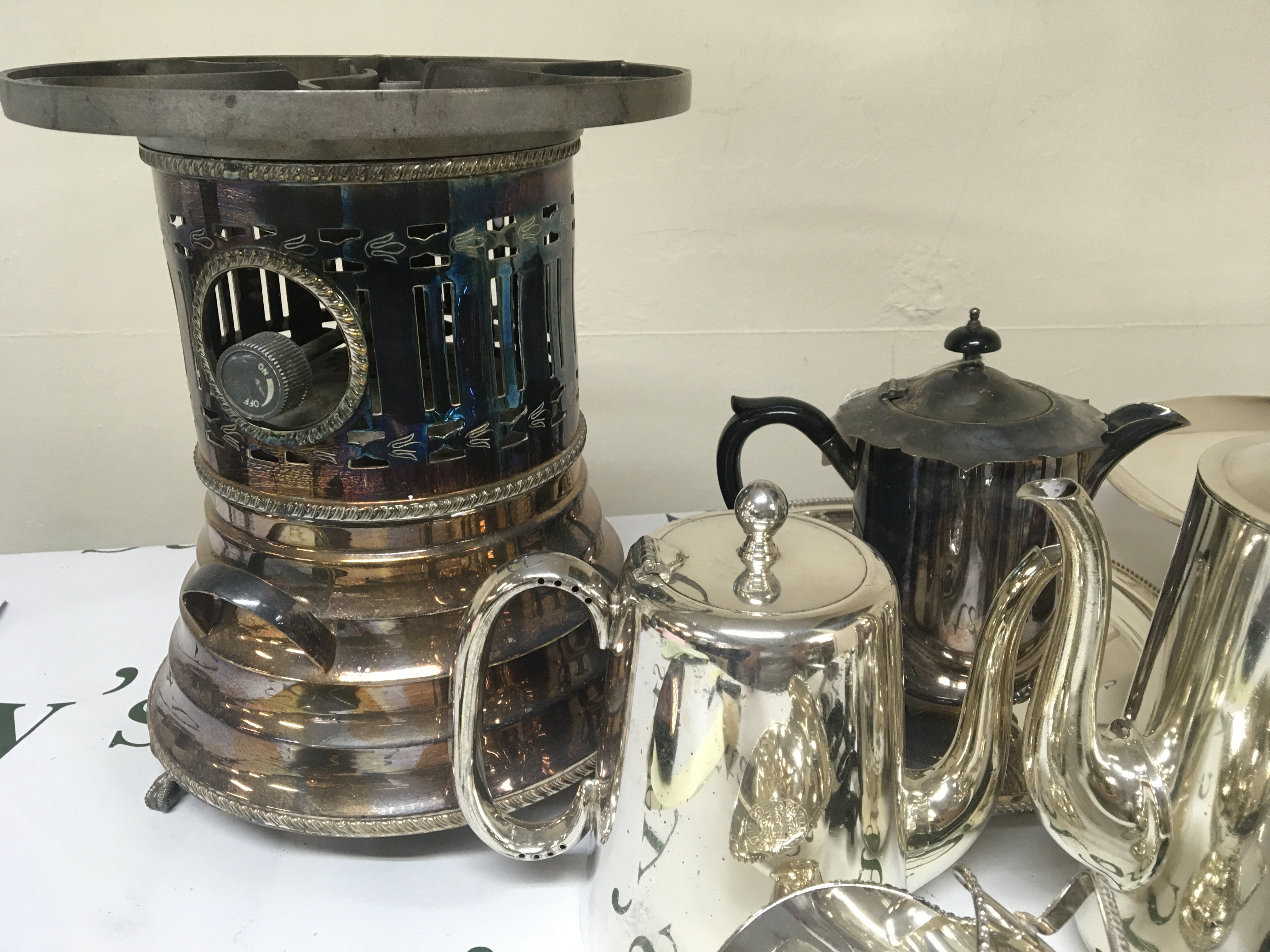 A box containing silver plate including a food warmer tea and coffee pots candle sticks and other ornaments including a vintage hanging scale NO RESERVE