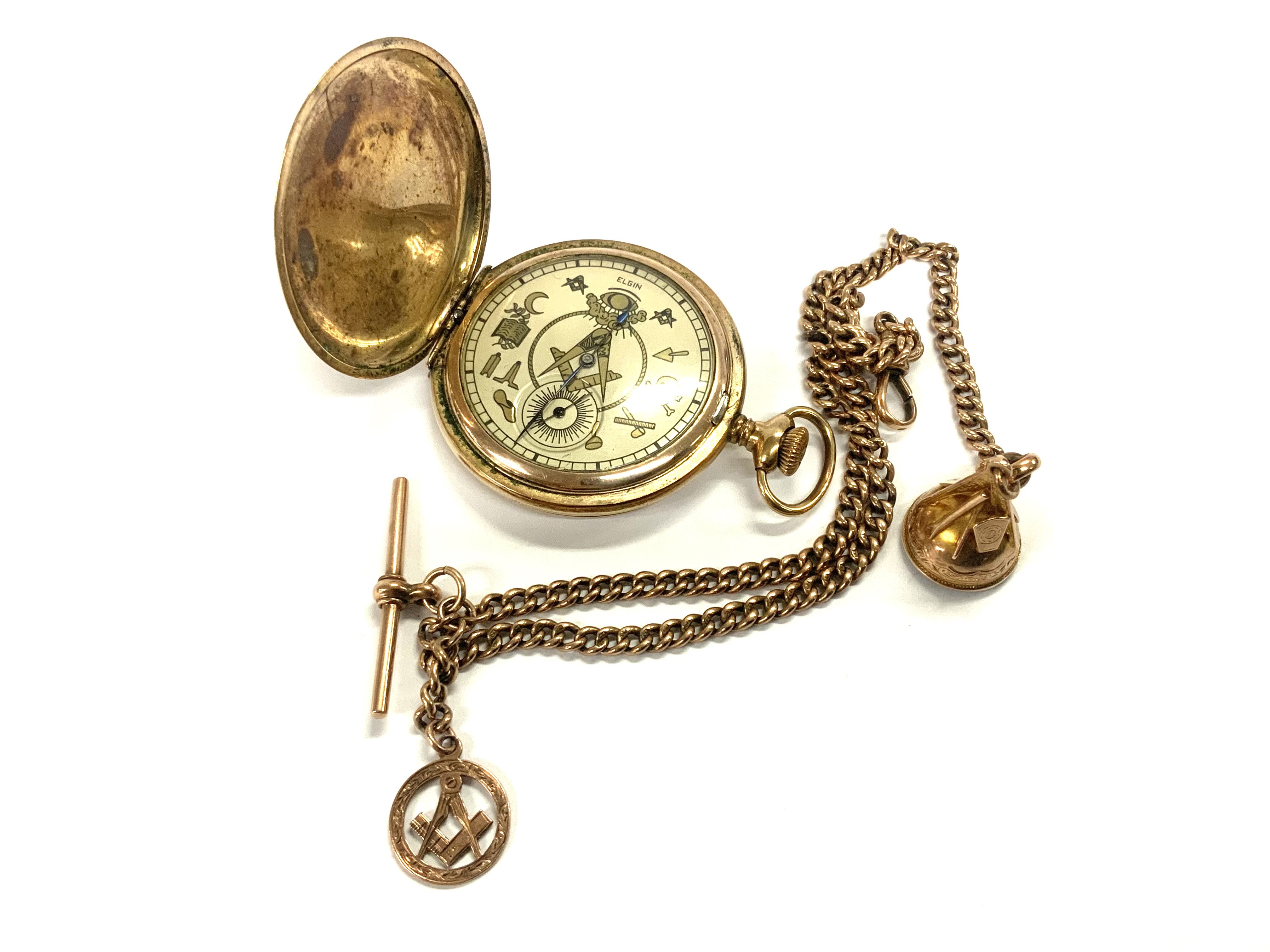 A vintage gold plated Elgin pocket with Masonic symbol dial, together with a 9ct gold Albert chain and attached Masonic fobs (Chain weight 21.14g)