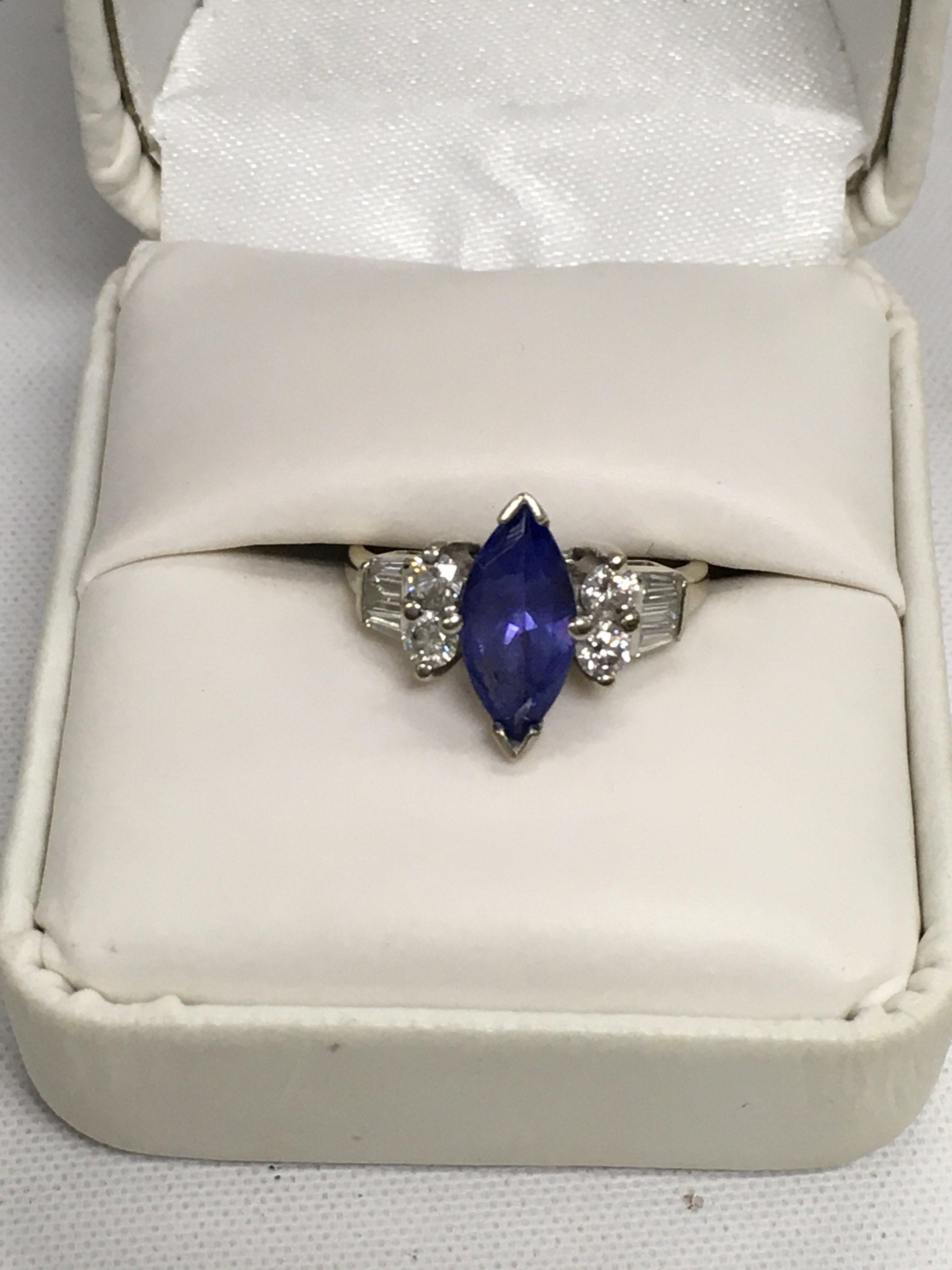 A 14ct white gold oval tanzanite with baguette and brilliant cut diamonds set on both shoulders. Approx weight 3.89 grams, size O.