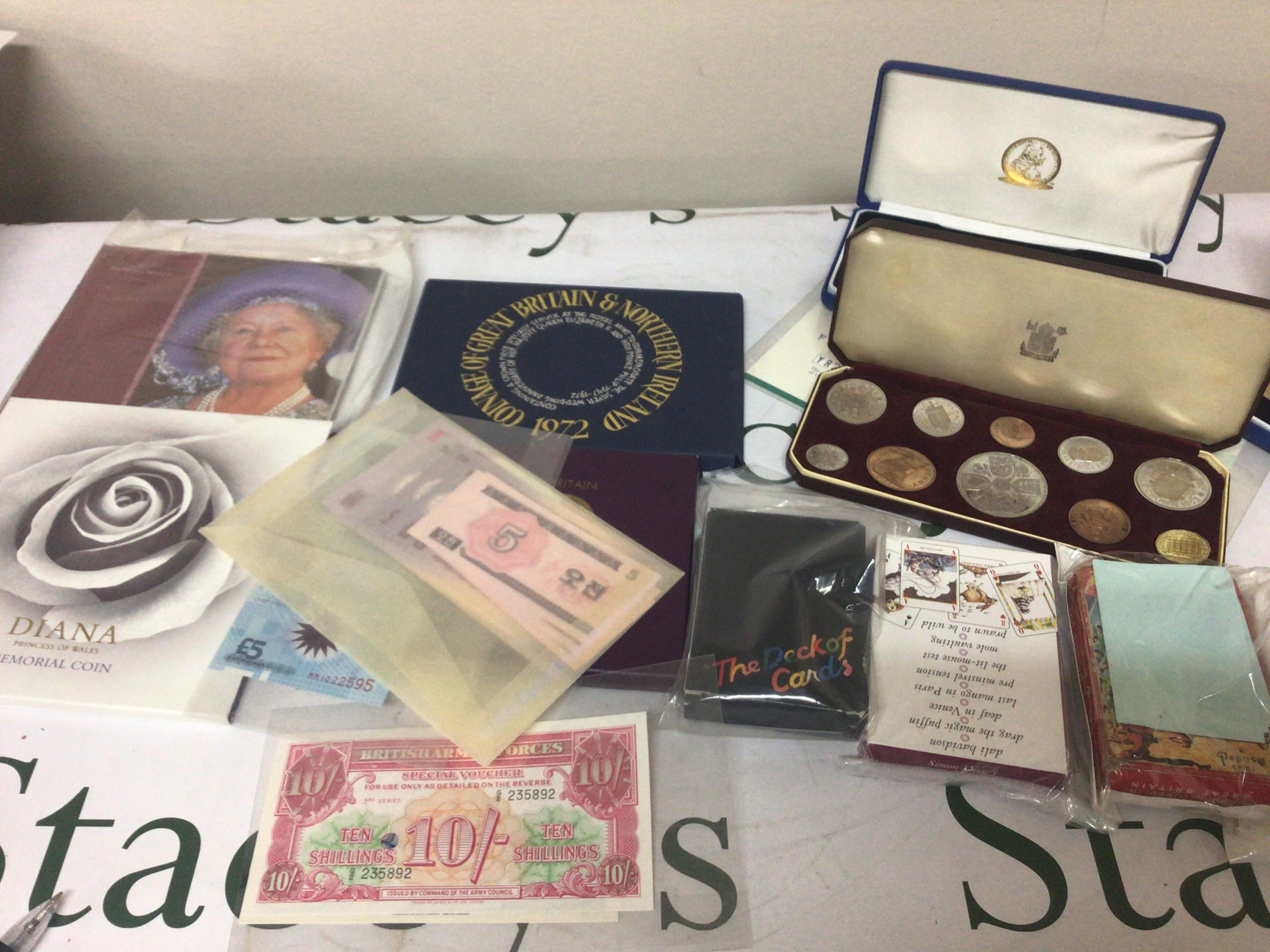 A cased 1953 proof coin set bank notes other commemorative coins and playing cards.