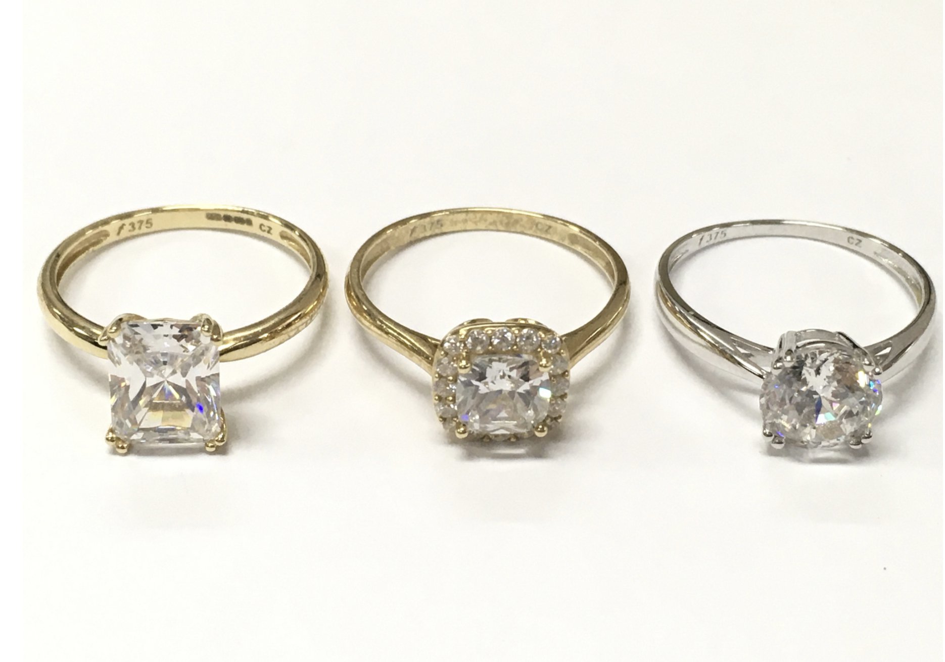 Three 9 carat gold rings set with cubic zirconia stones , size P. 6.6g total weight. Postage category A