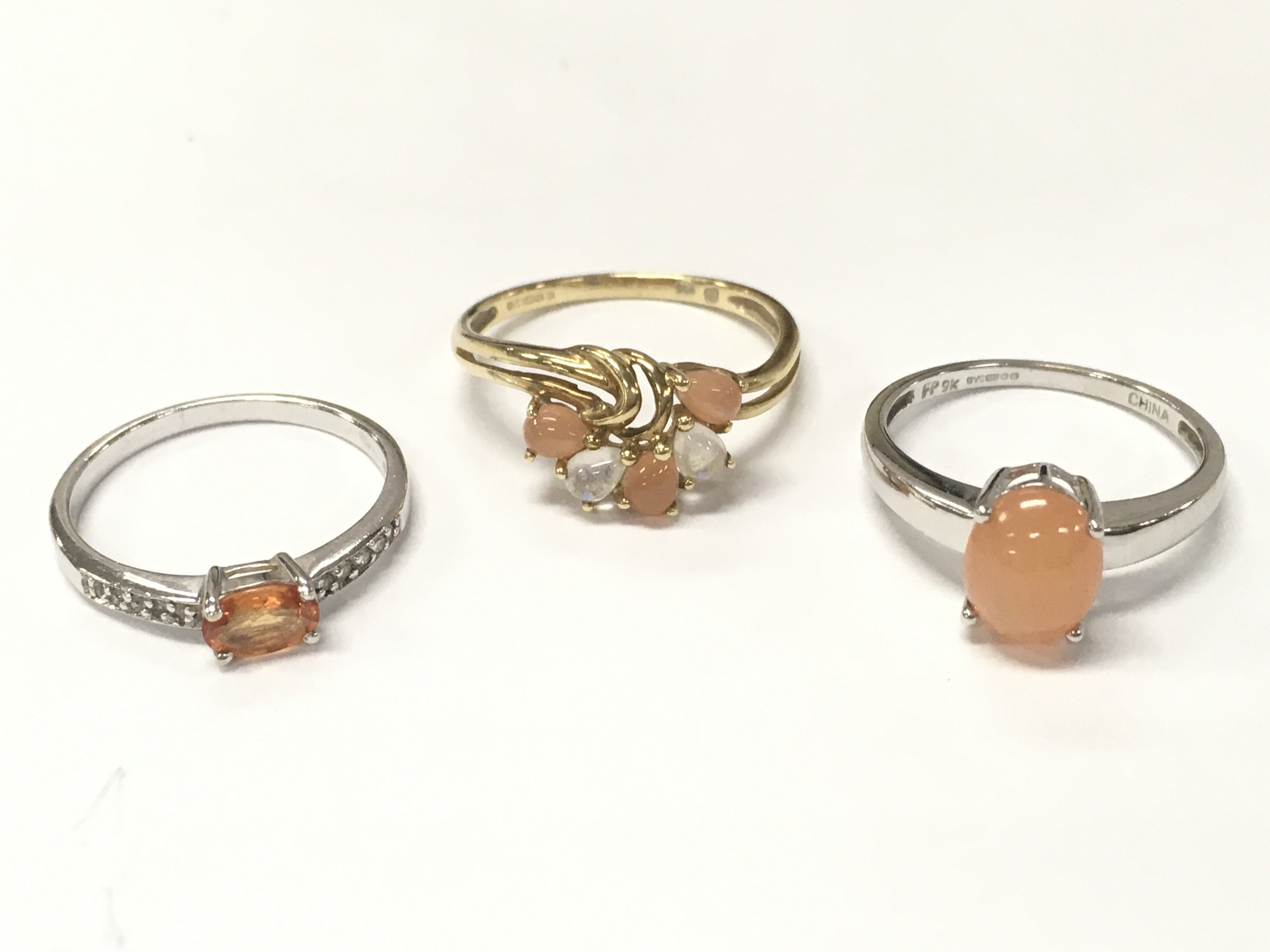 Three 9 carat gold rings including a white gold peach moonstone ring, pearl peach and opal cluster and citrine . 6g total weight. Size P-O, Q, O. Postage category A