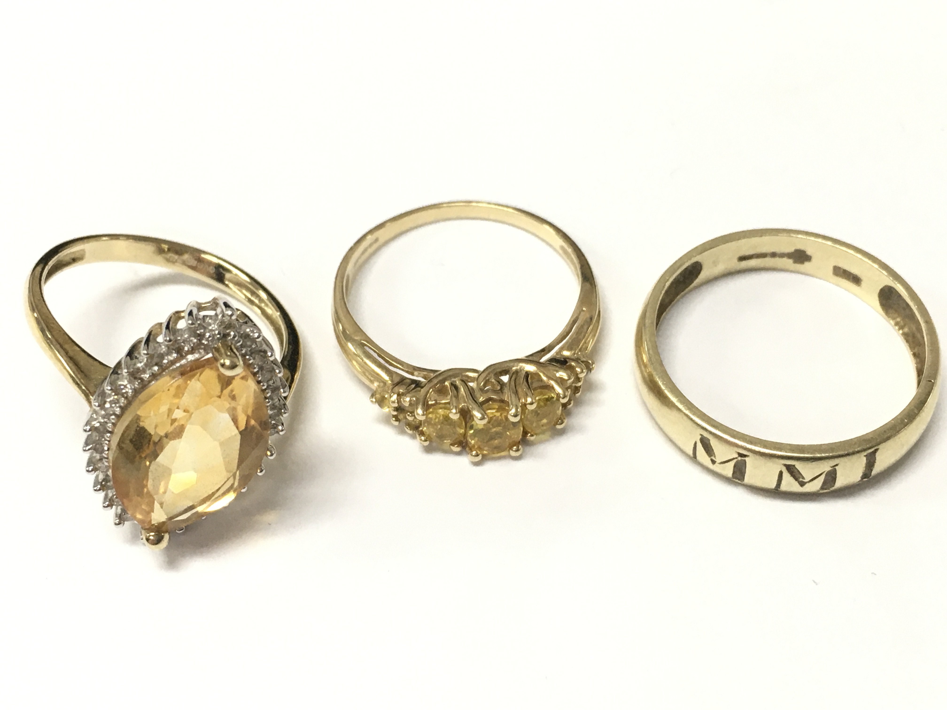Three 9 carat gold rings including a citrine cocktail ring, MMI ring, yellow sapphire dress ring. 9.3G total weight. Postage cat A