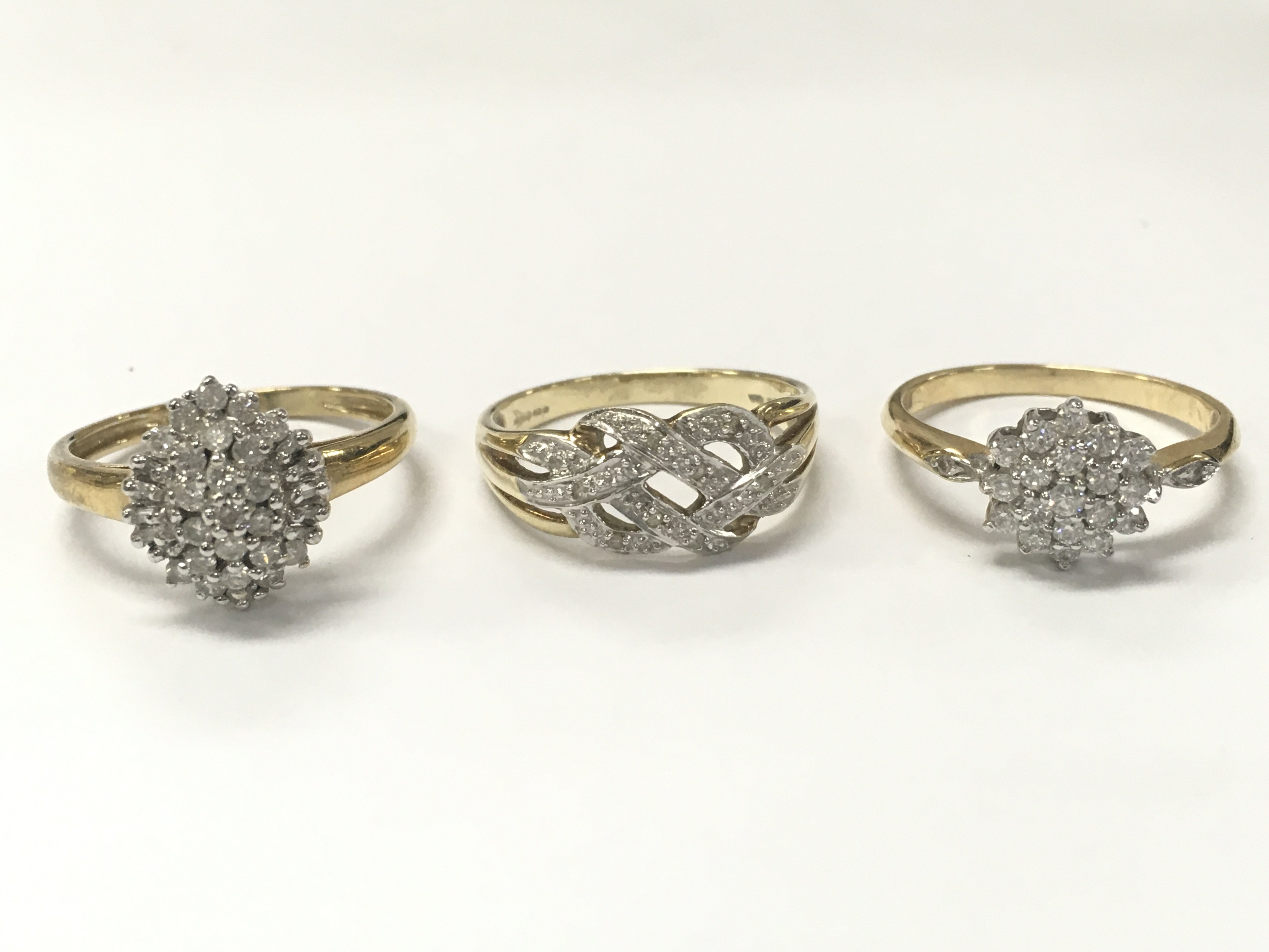Two 9 carat gold rings (white stone cluster and knot ring) and one 14ct gold ring cubic zirconia cluster ring. Total weight 8.6g . Sizes R & Q.Postage category A