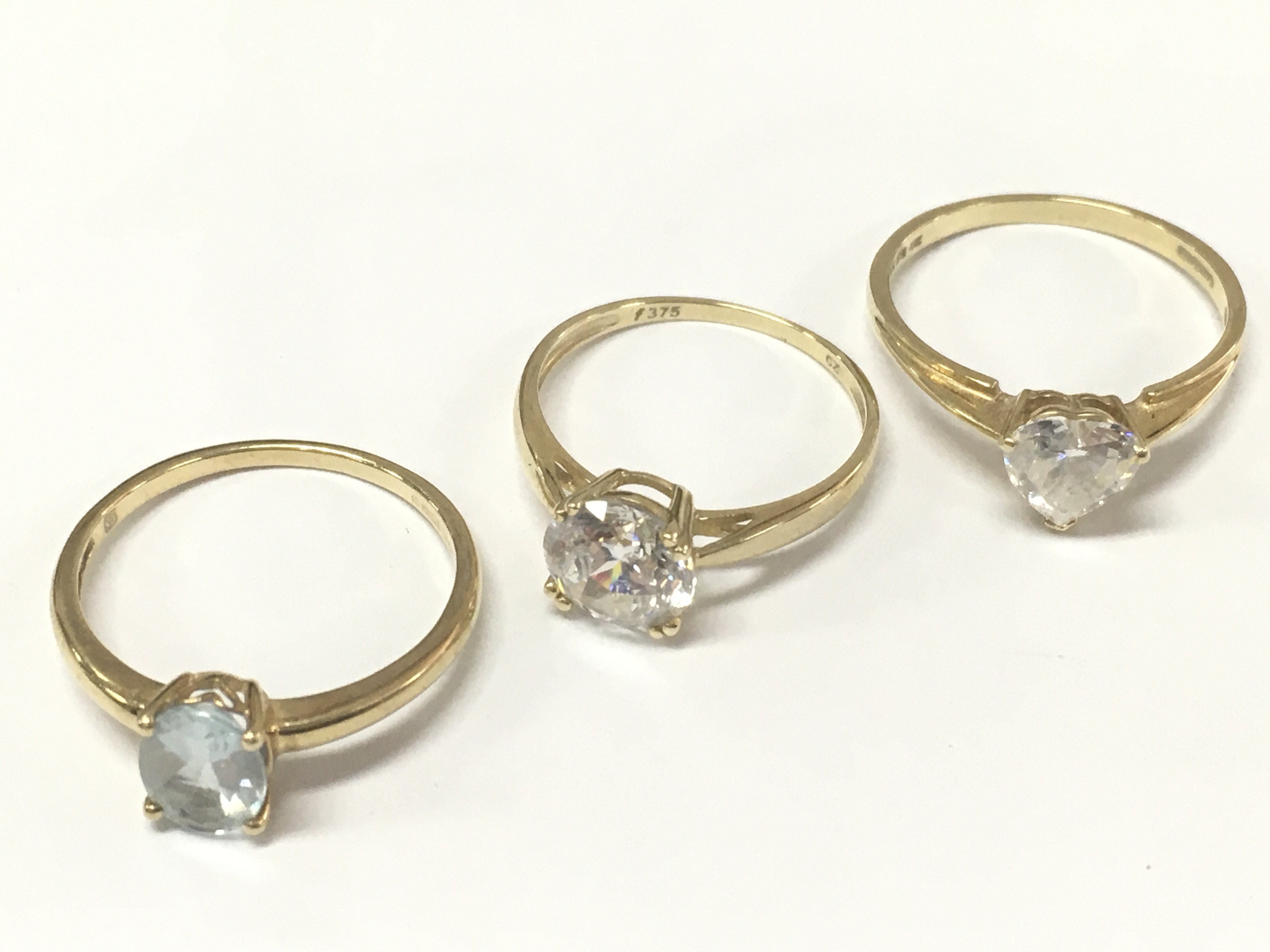 Two 9 carat gold rings - cubic zirconia set size P total weight 2g , 14ct gold heart shaped cubic zirconia ring 2.1g size R and a 9 carat aquamarine ring 1.8g size Q. Postage category A