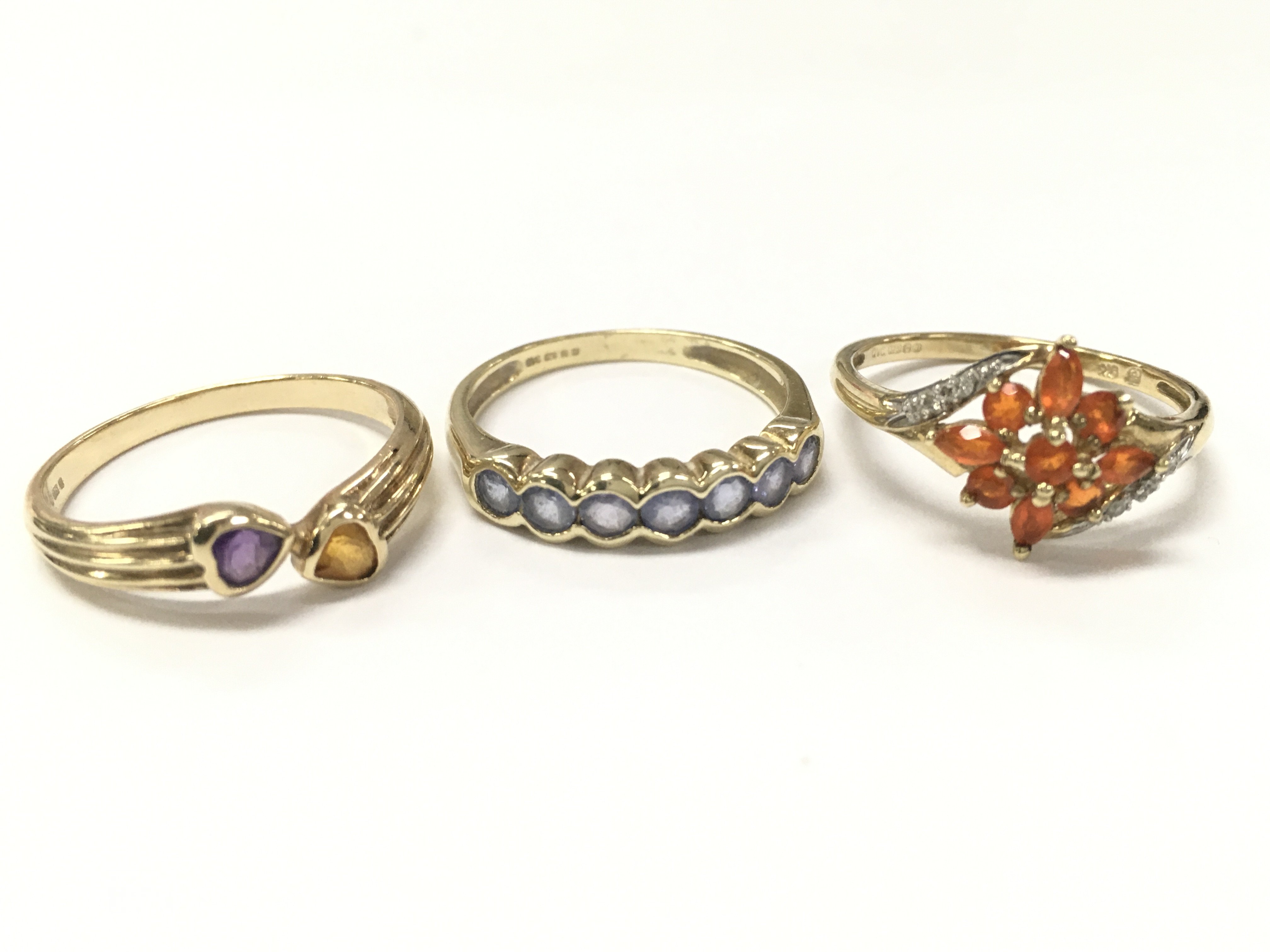 Three 9ct gold rings including an amethyst & citrine set ring size Q, light blue stone half eternity ring size R, Fire Opal set ring size R. 6.4g total weight. Postage category A