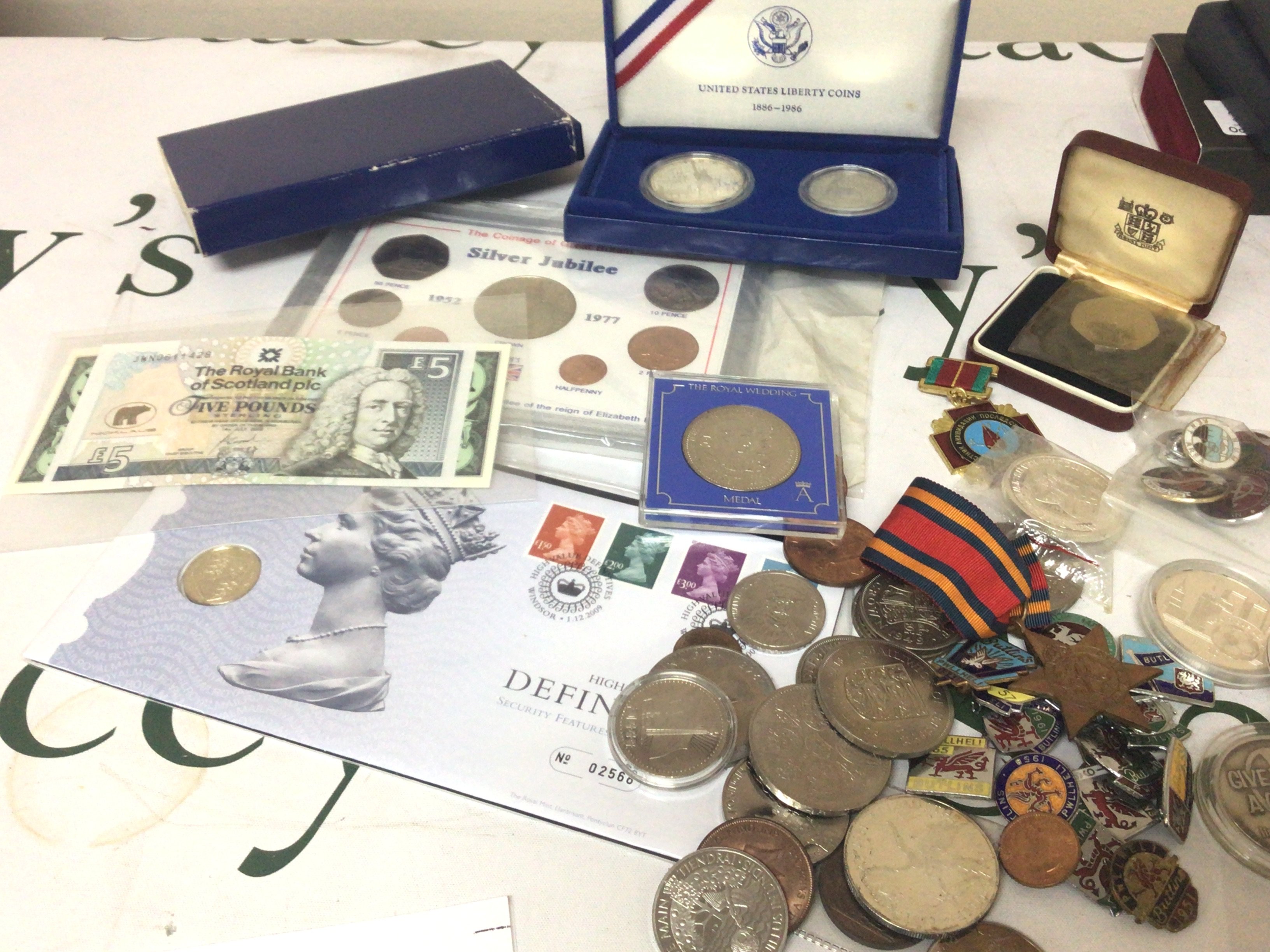 A collection of Coins including 1986 commemorative Liberty coins cased badges including 1950s Butlins badges coins including some silver coinage a II world War Burma Star bank notes and other coins