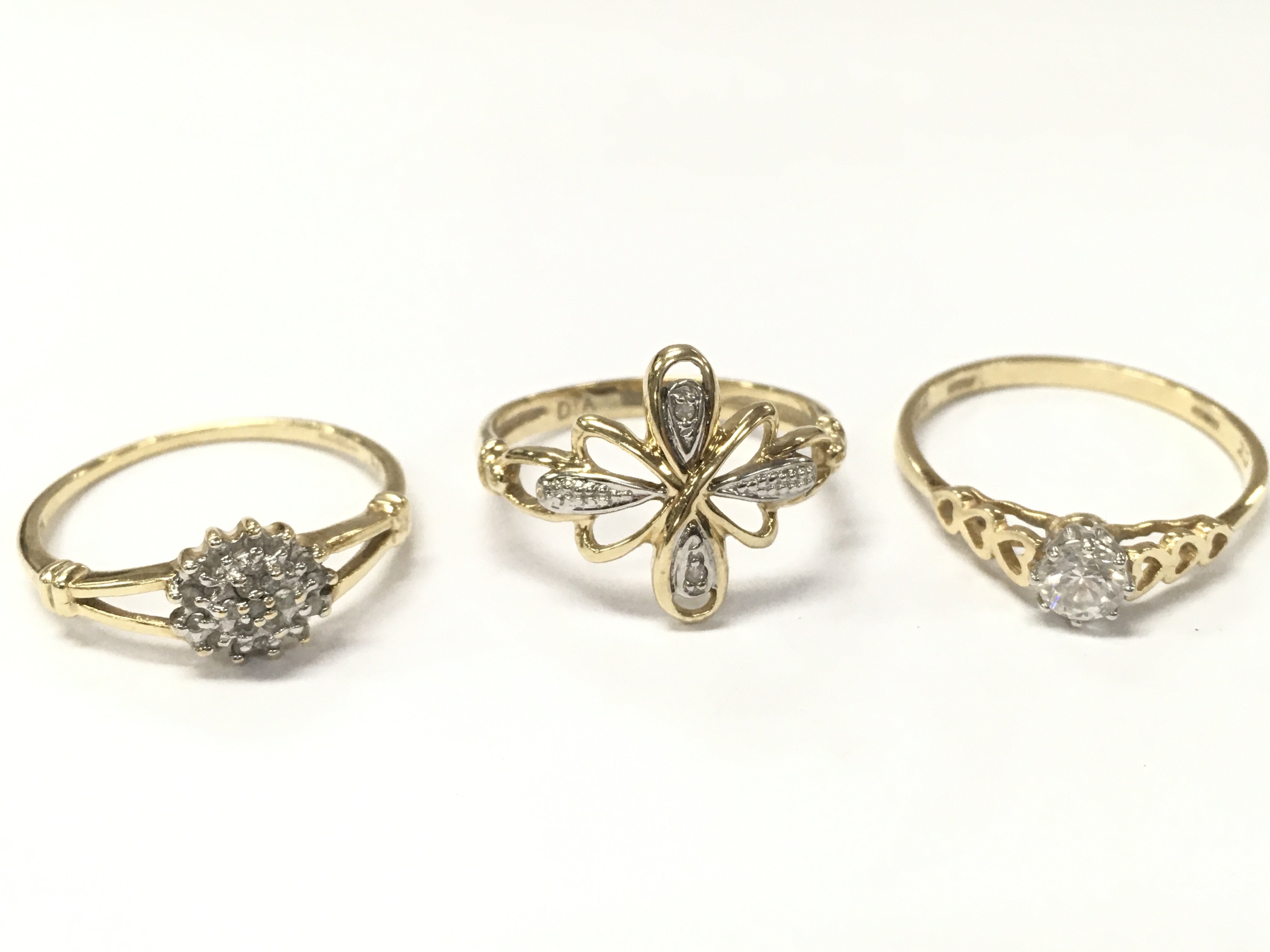 Three 9 carat gold rings including a white stone cluster ring size P, flower diamond chip set ring size O/P, cubic zirconia set heart design ring size R. Total weight 5.1g, postage cat A