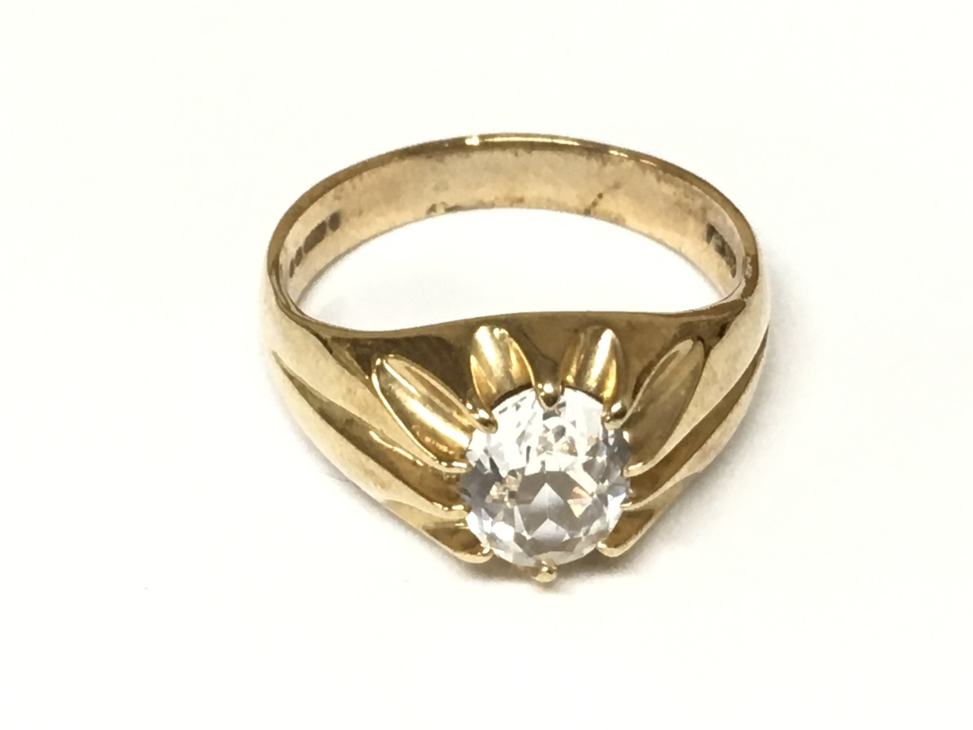 A gents 9ct gold ring set with a large white stone. 5.60g and size U