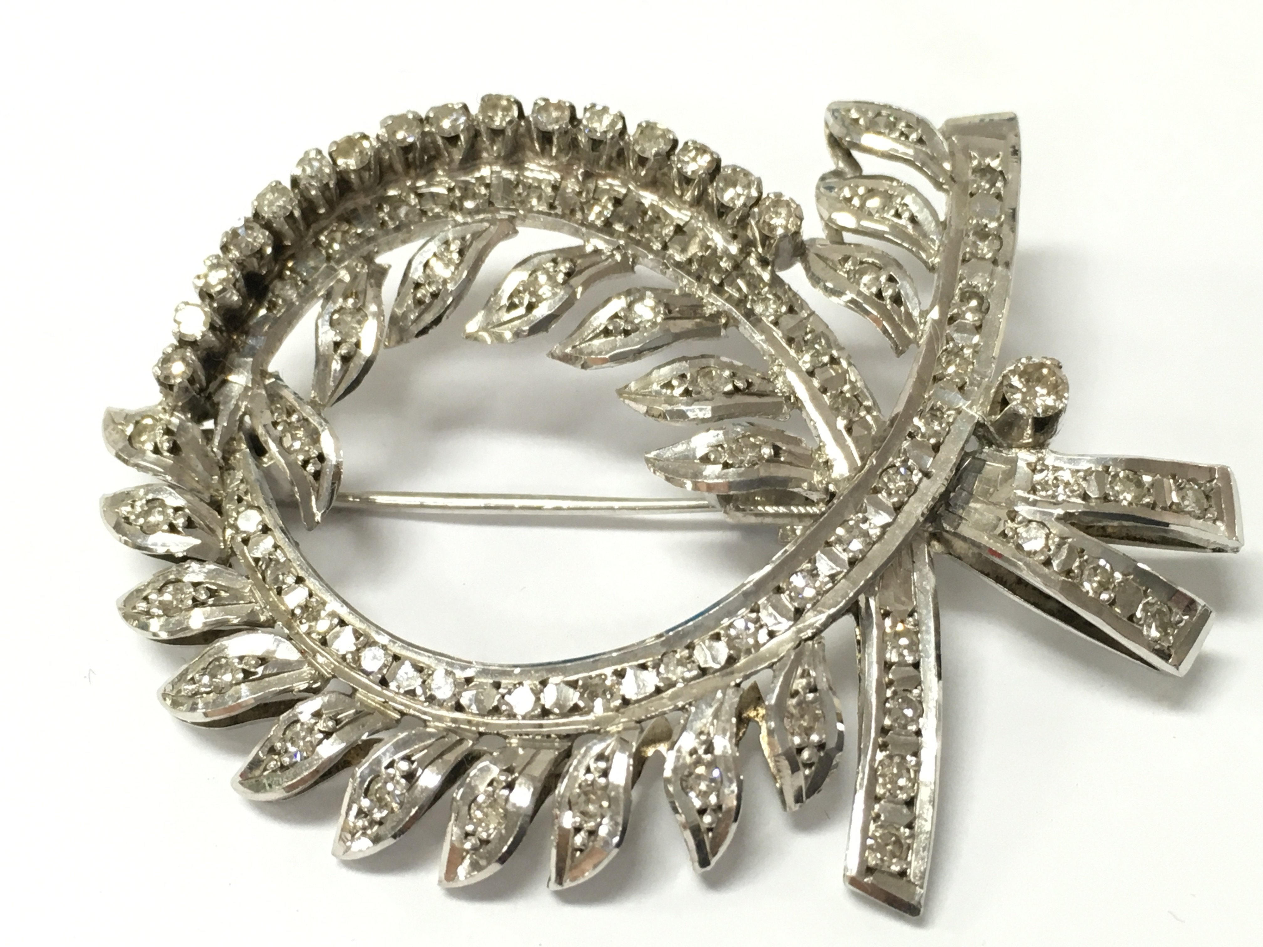 A fine quality unmarked gold wreath brooch inset with a pattern of diamonds. (Tested min 14ct).