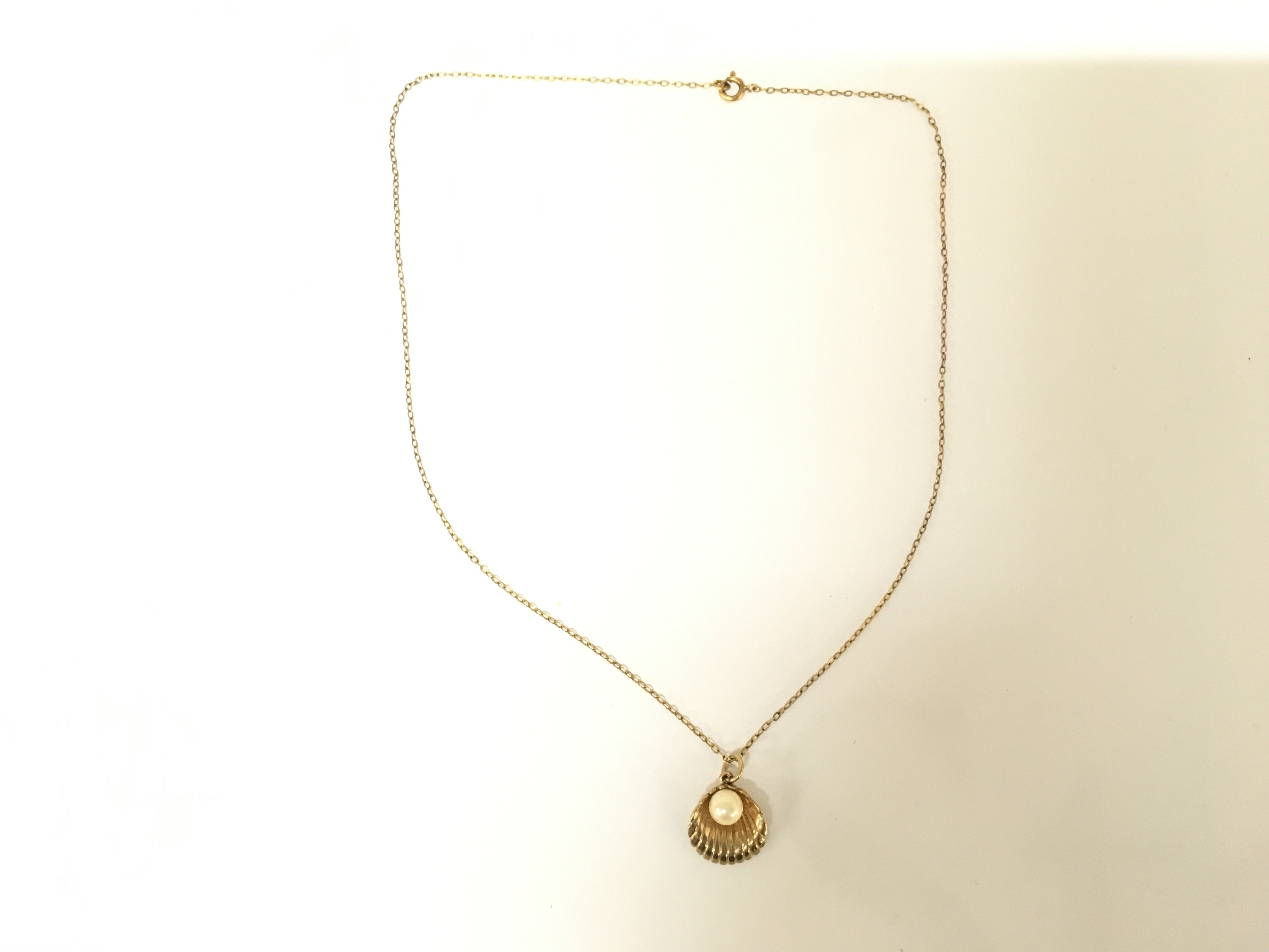 A 9ct gold shell pendant on 9ct gold chain. 2.33g