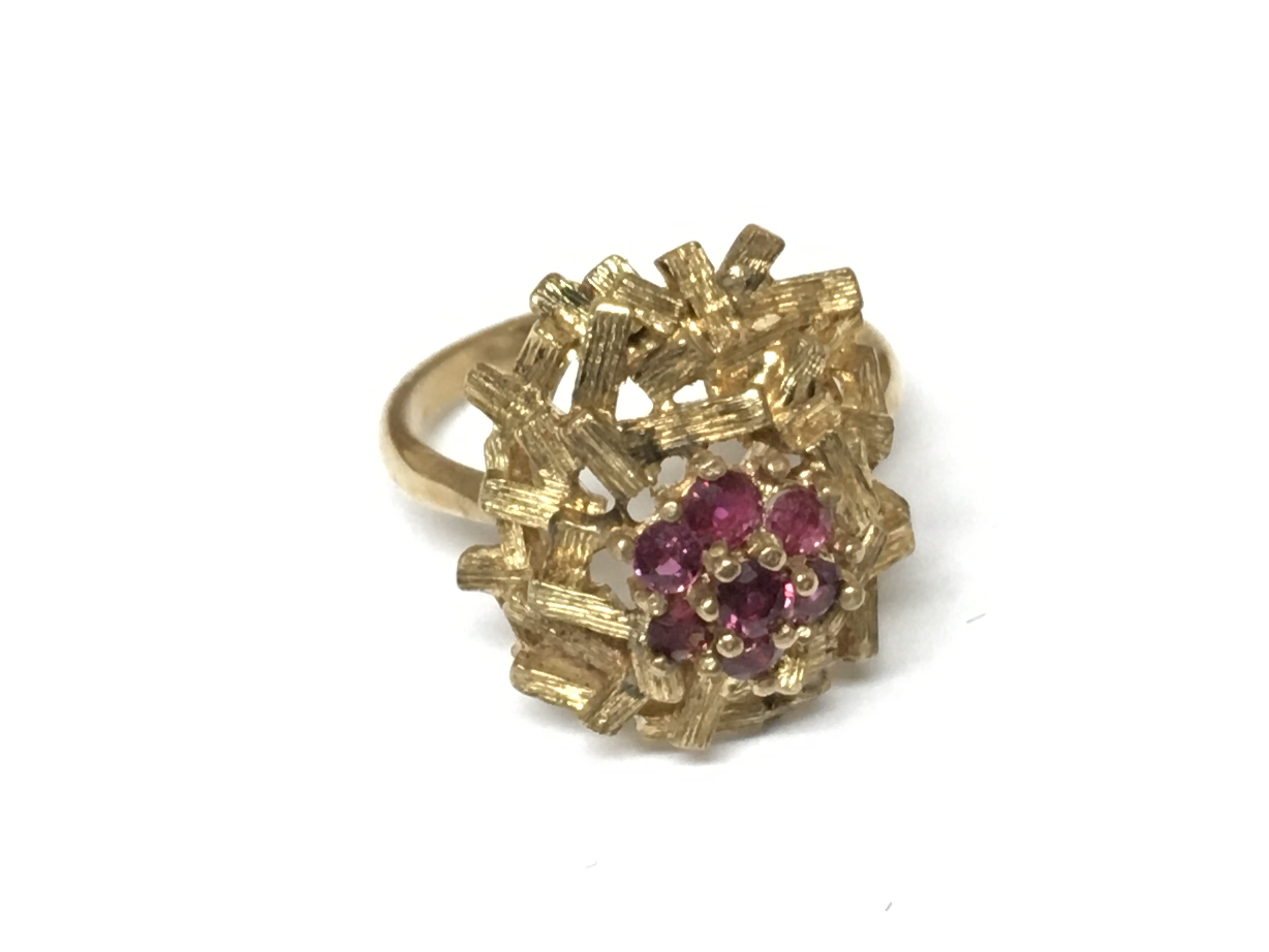 An unmarked floral ring set with rubies. Size M 1/2 and 5.11g