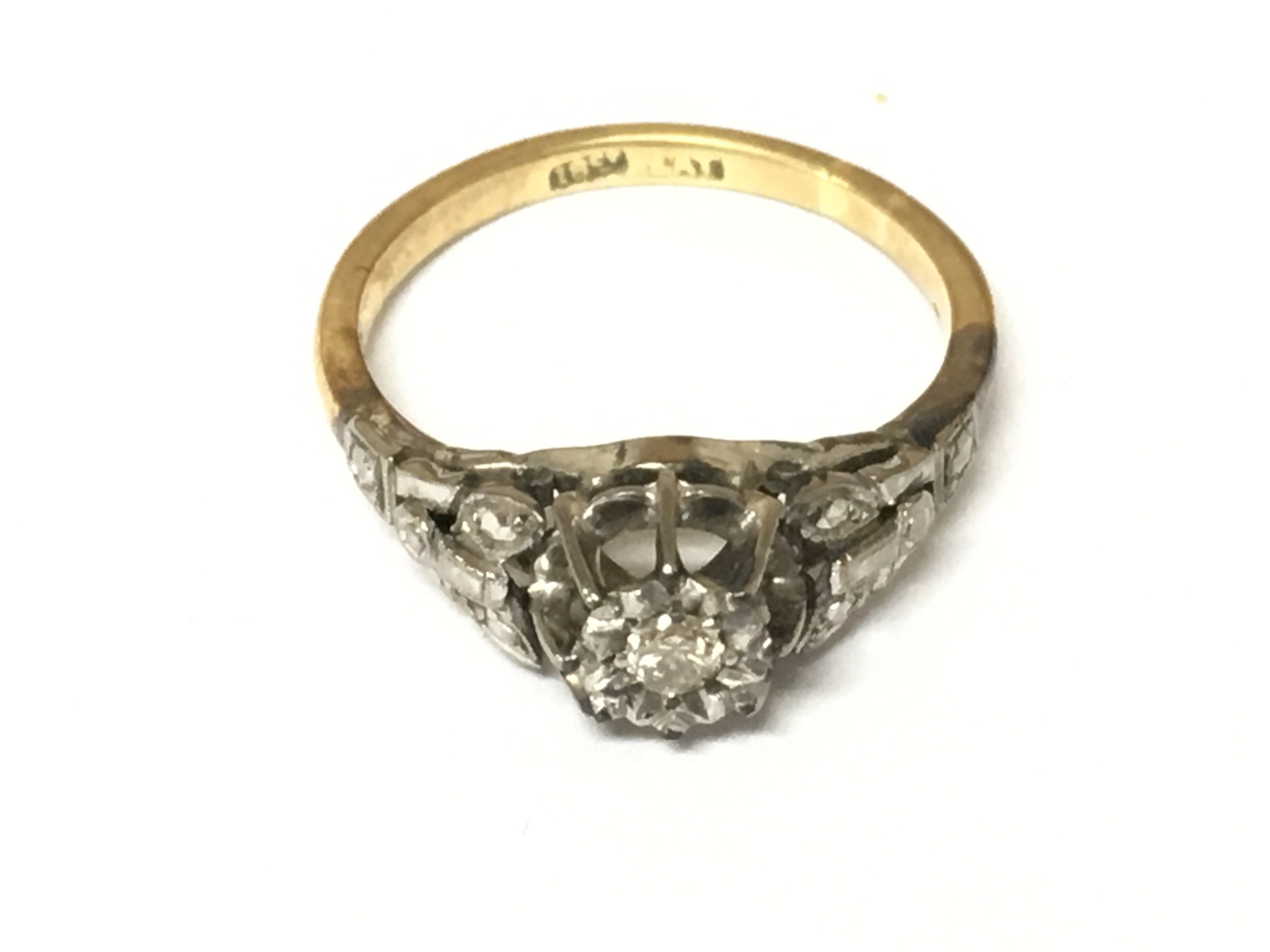 An 18ct gold and platinum ring set with diamonds. Size O and 3.35g