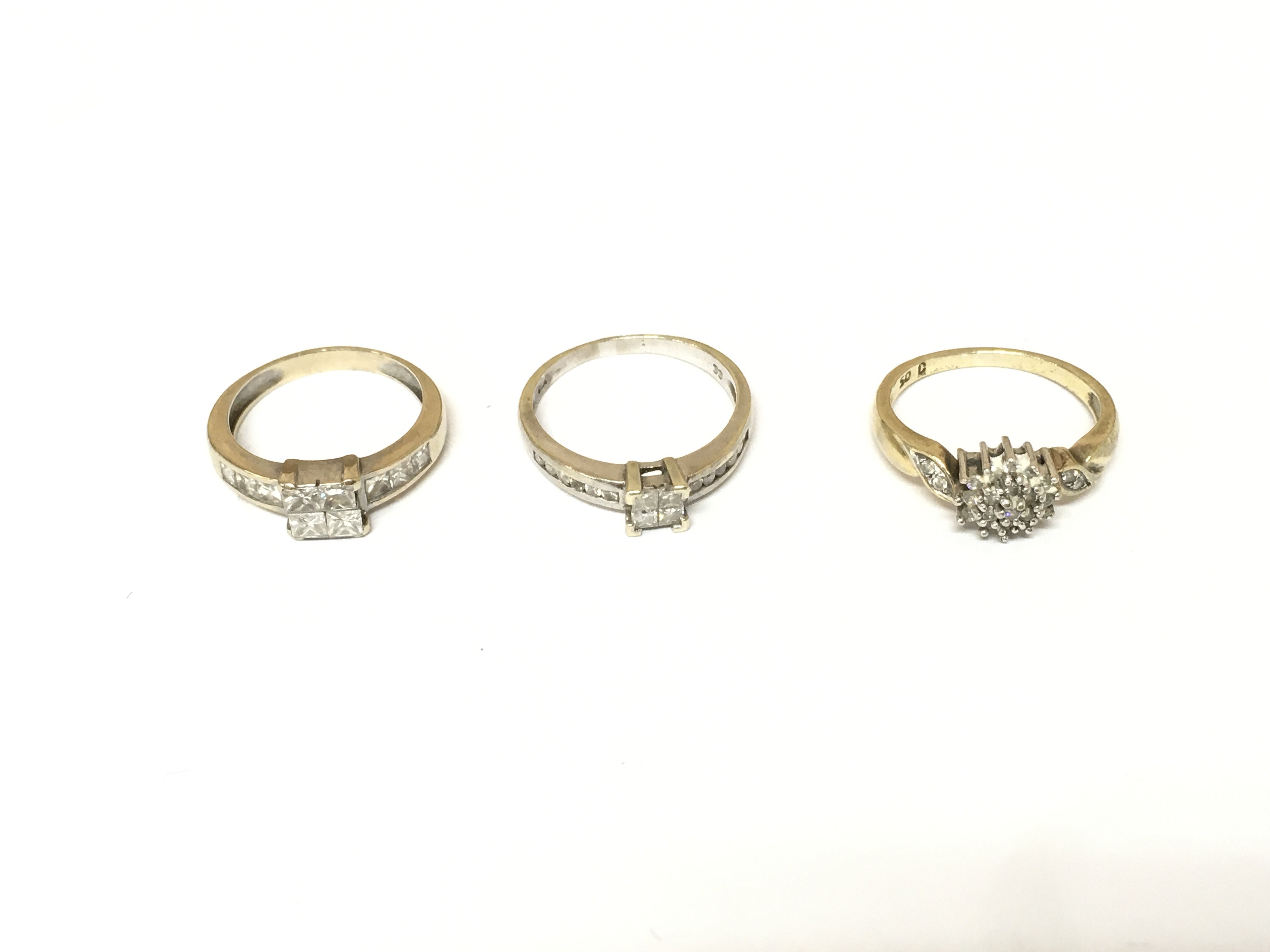 Three unmarked cluster rings two set with diamonds. Approximately 8.2g and sizes K M N 1/2