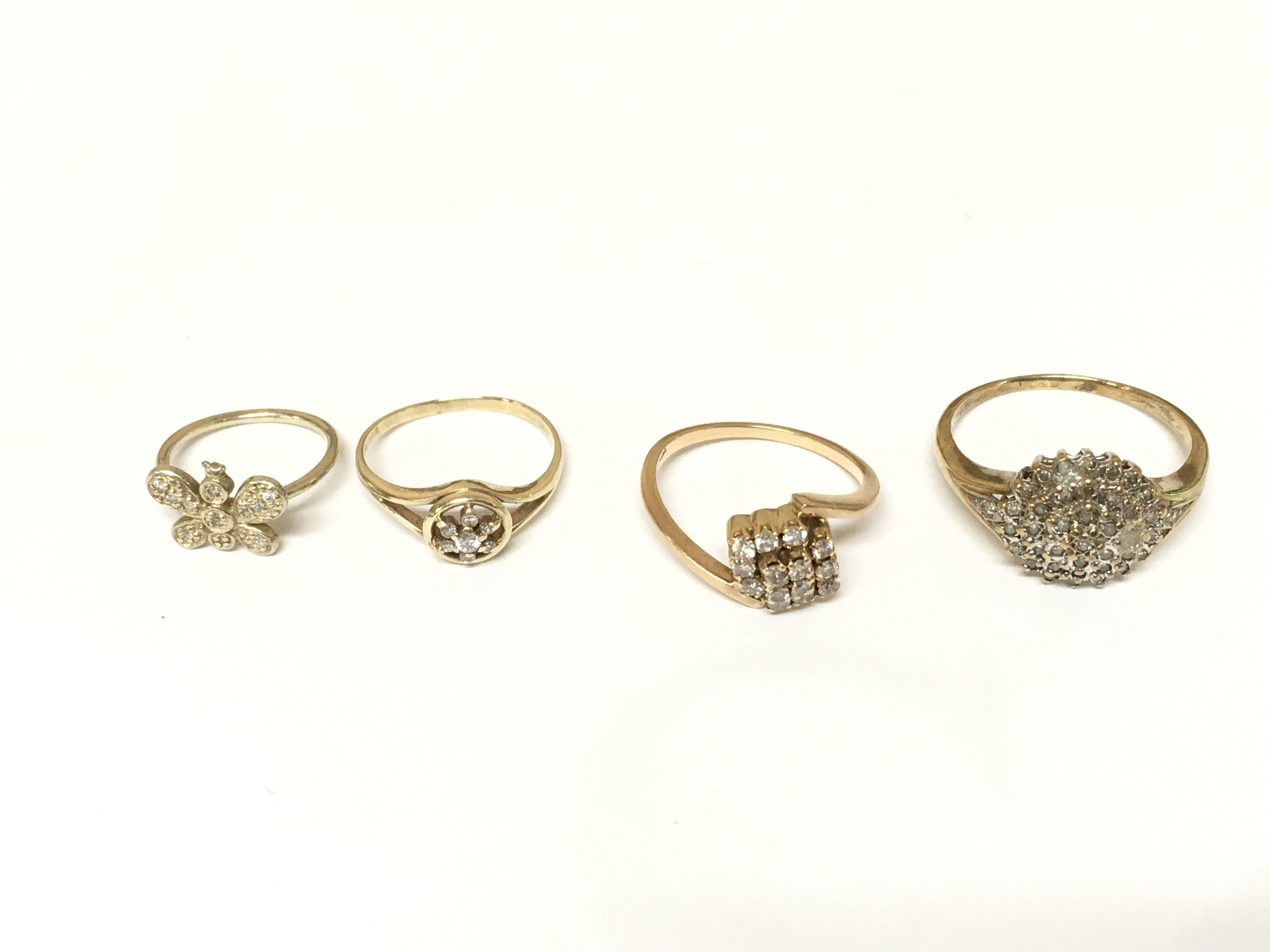 Four unmarked cluster rings set with diamonds. Approximately 8.2g and sizes C 1/2 K M and S