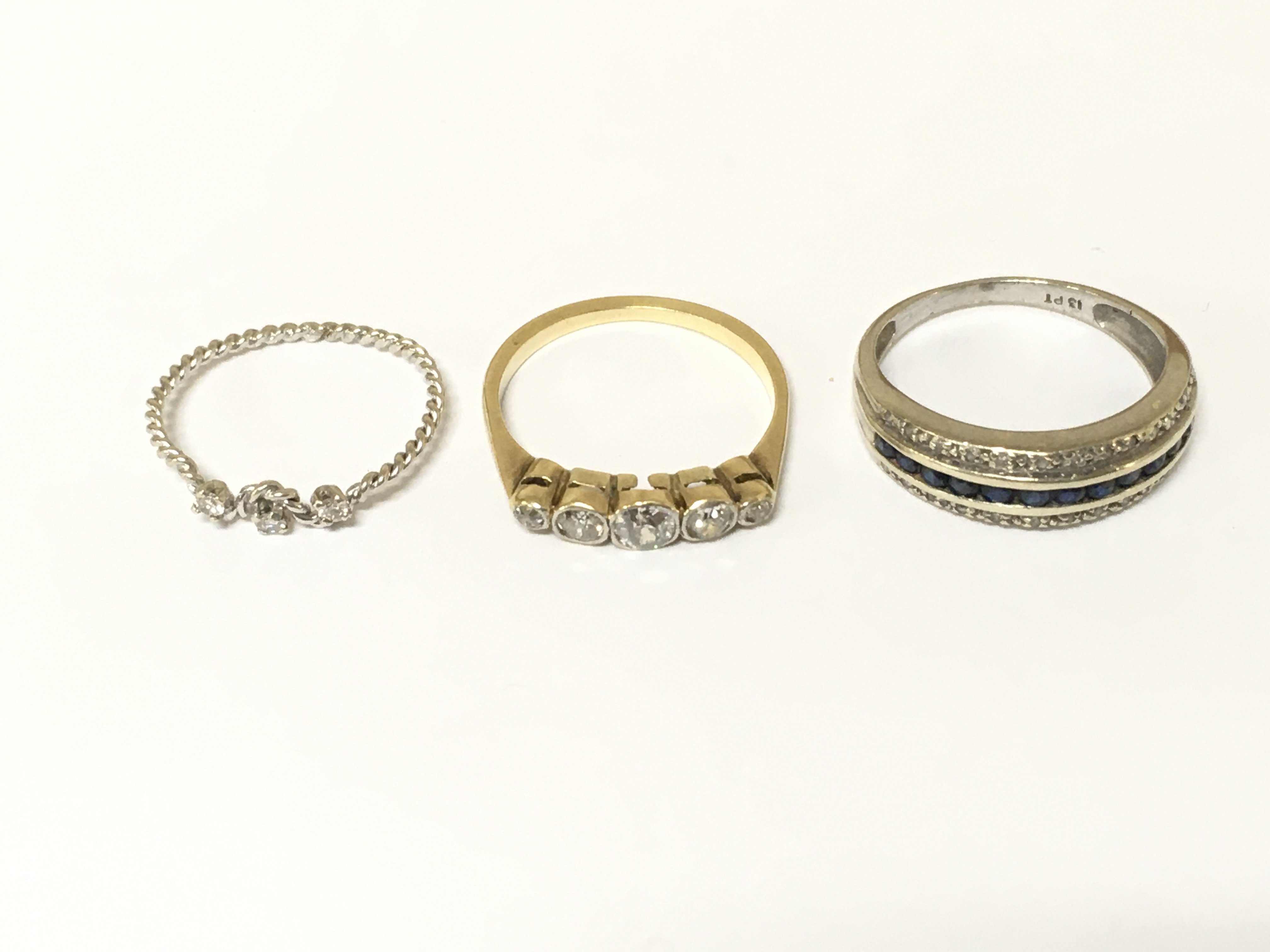 Three unmarked rings set with various gems including diamonds. Approximately 6g sizes K N and O