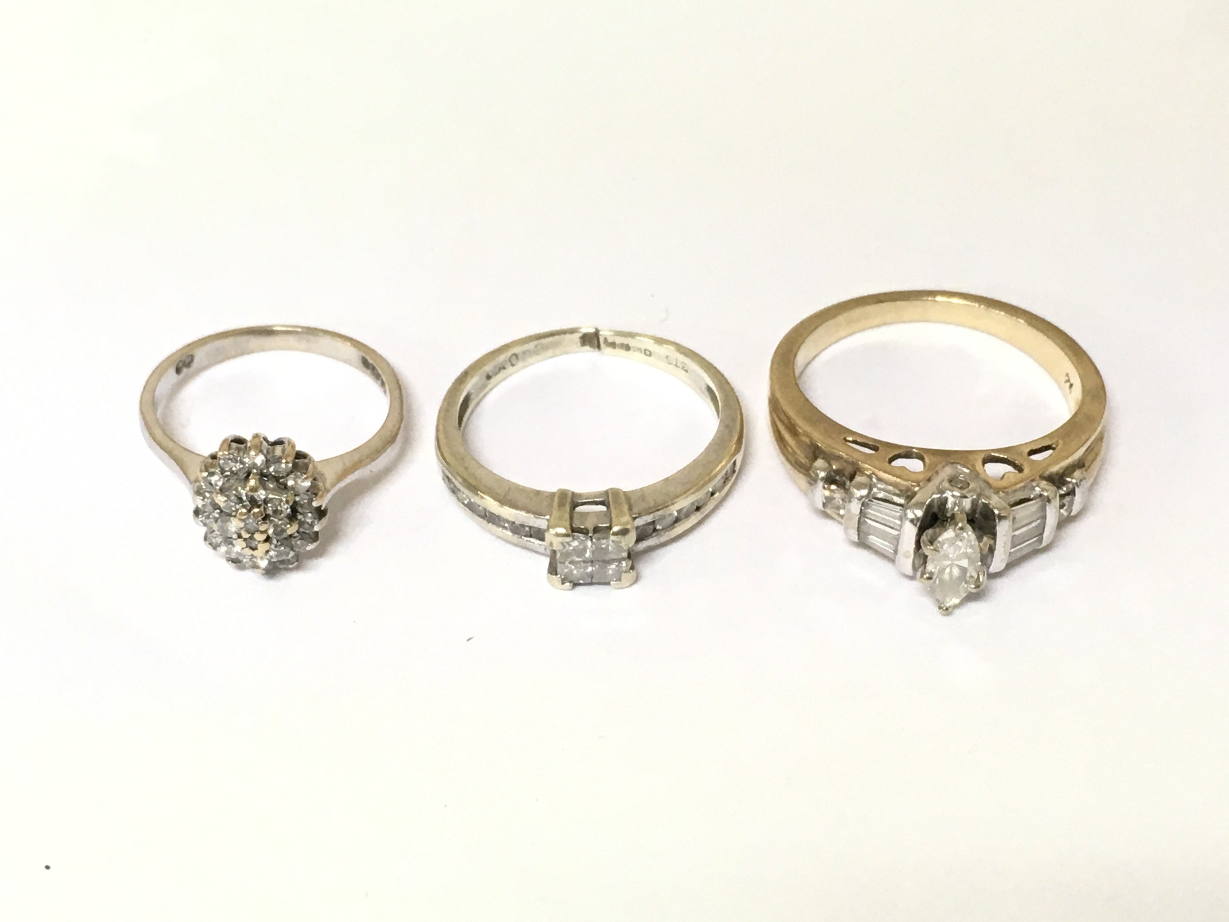 Three 9ct gold diamond cluster rings two are white gold. Approximately 8.3g and sizes F J and M 1/2