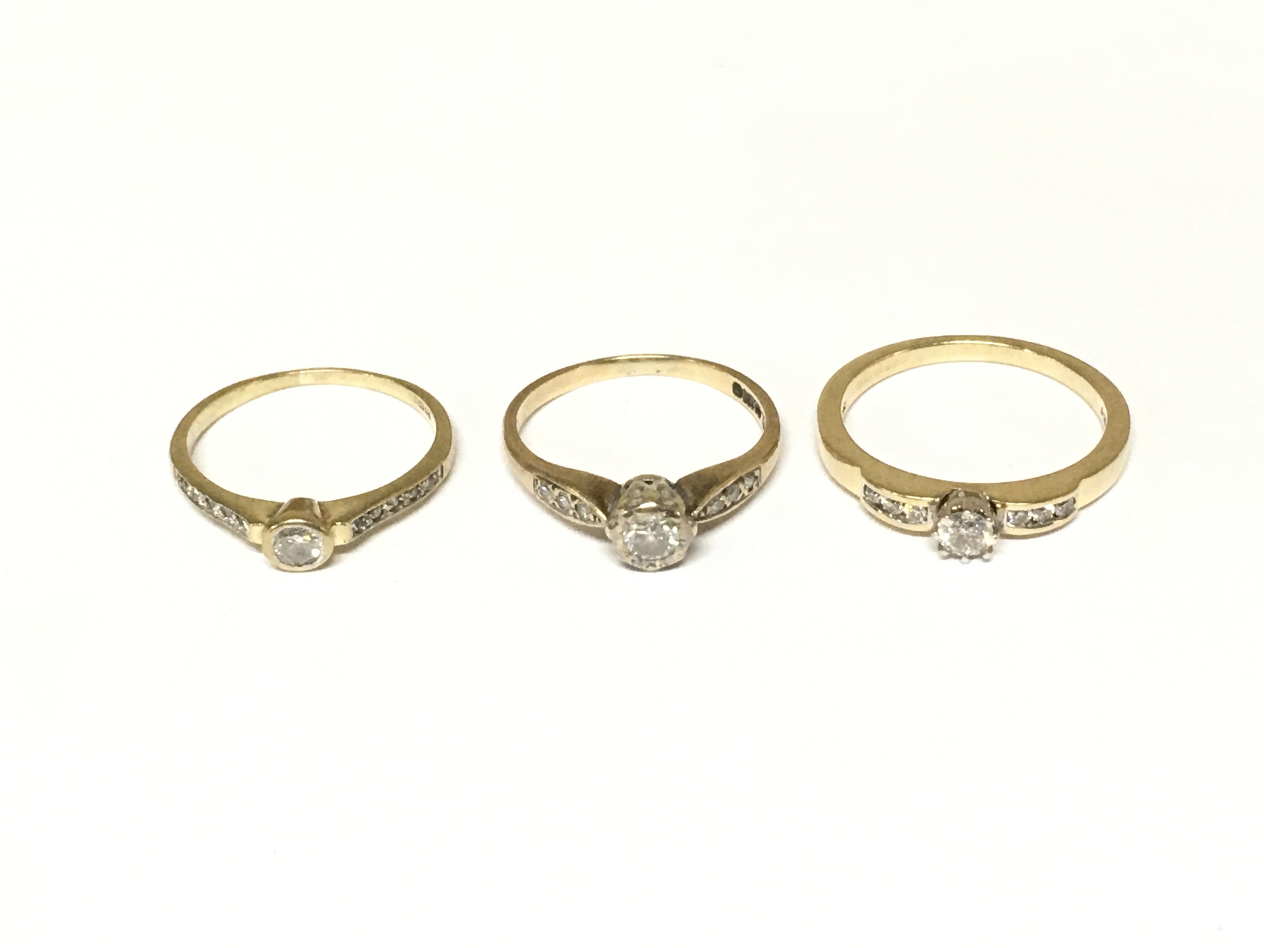 Three 9ct gold diamond solitaire rings with diamond shoulders. Approximately 5.4g and sizes L and N