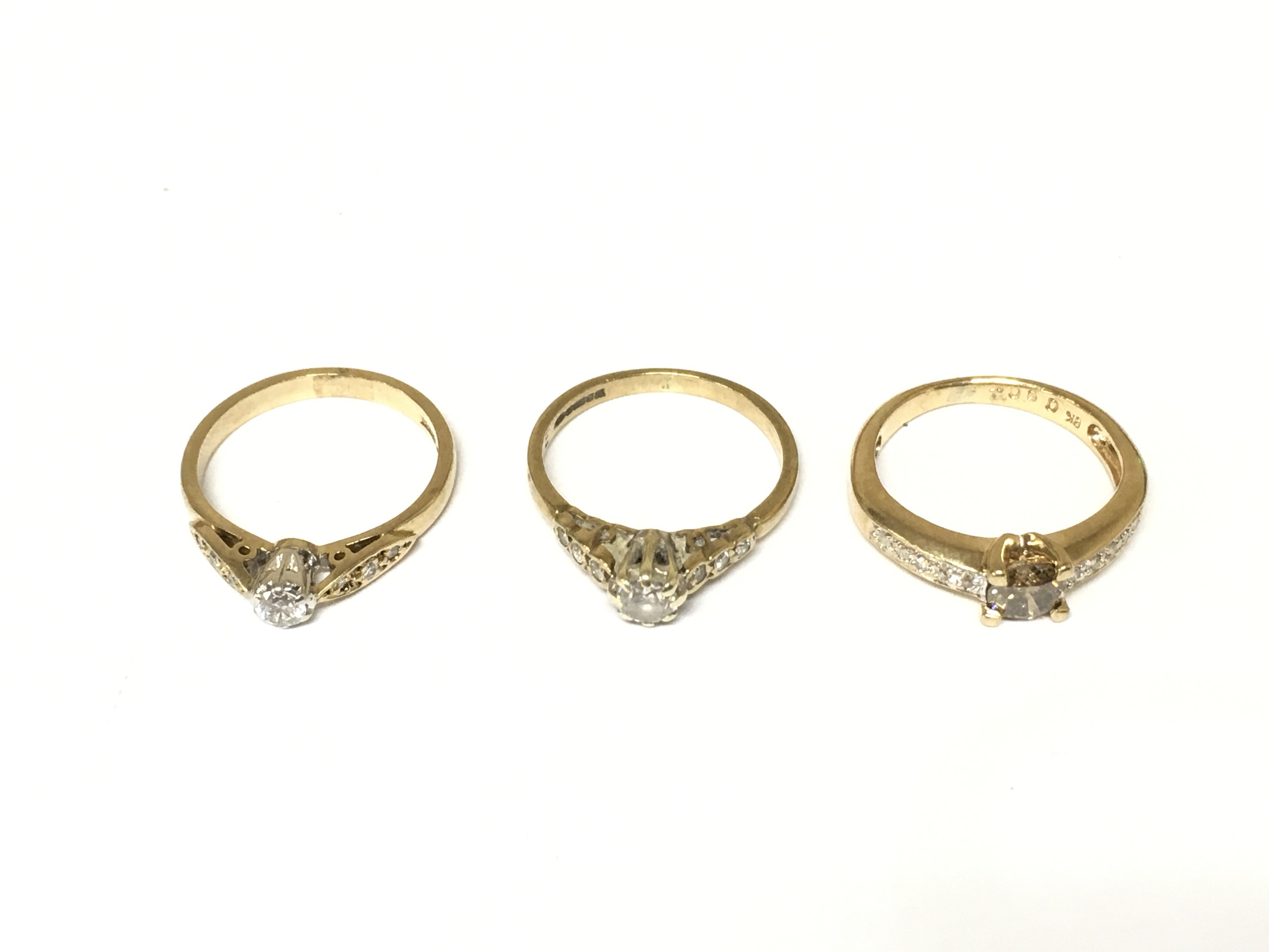 Three 9ct gold diamond solitaire rings with diamond shoulders. Approximately 5.6g and sizes I and I 1/2