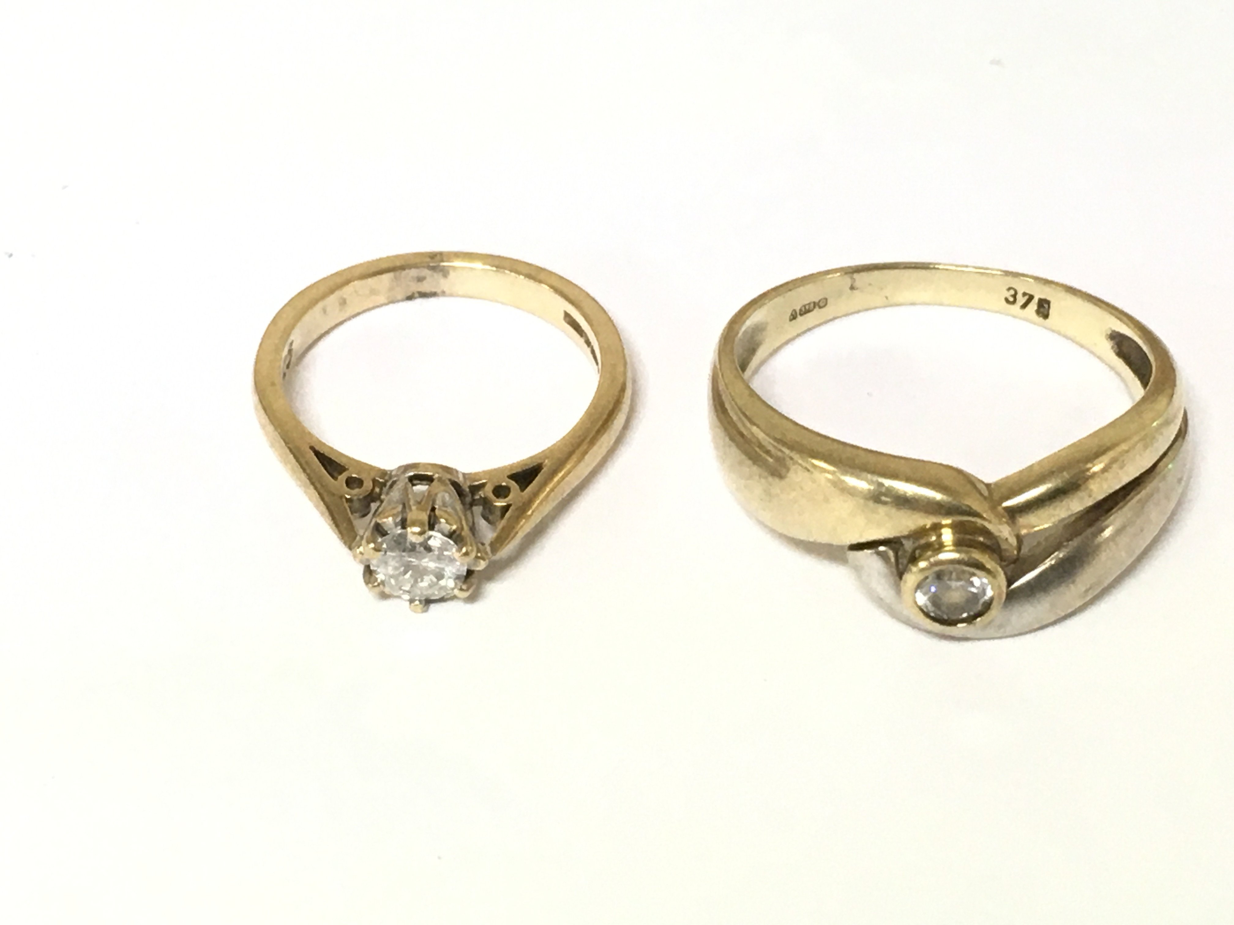 Two 9ct gold rings one set with diamond solitaire and other with white stone. Approximately 5.7g and sizes G Q