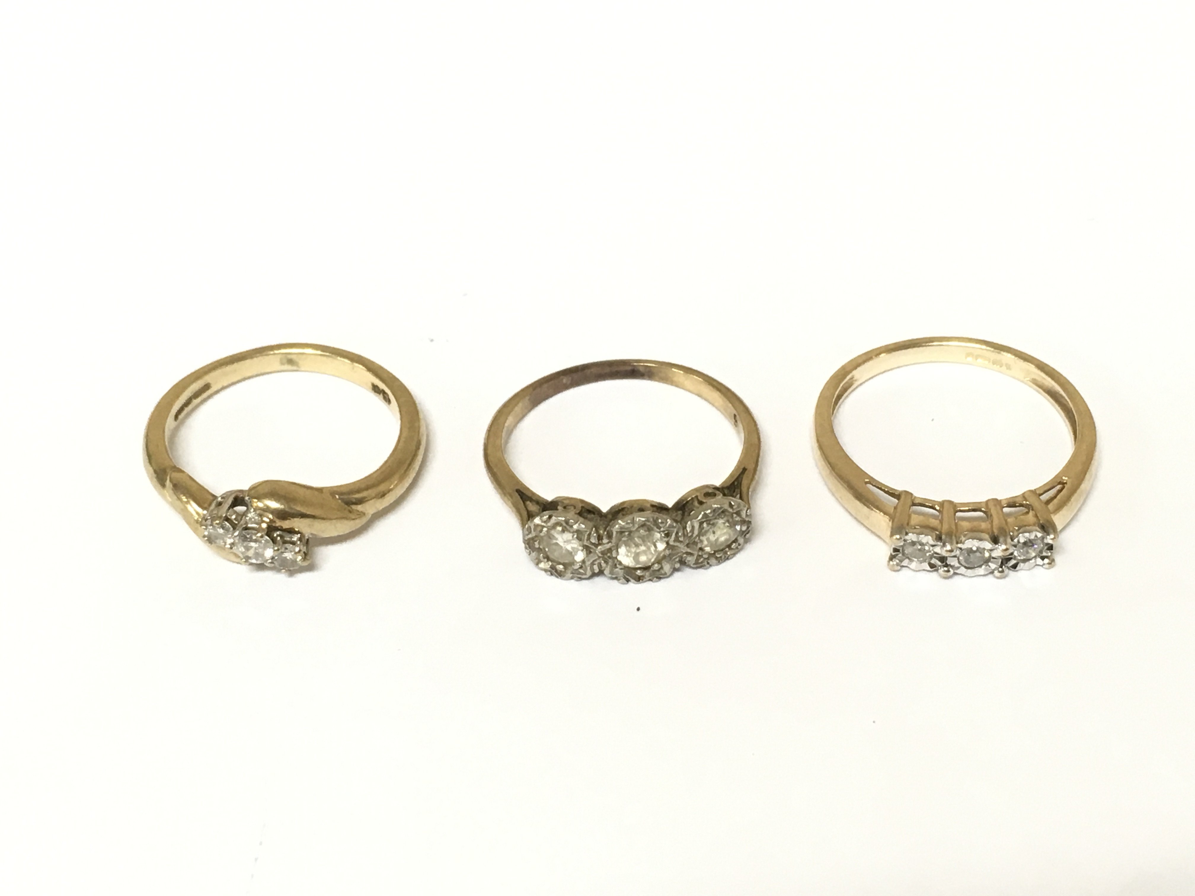 Three 9ct gold three stone diamond rings. Approximately 6.7g and sizes J and L