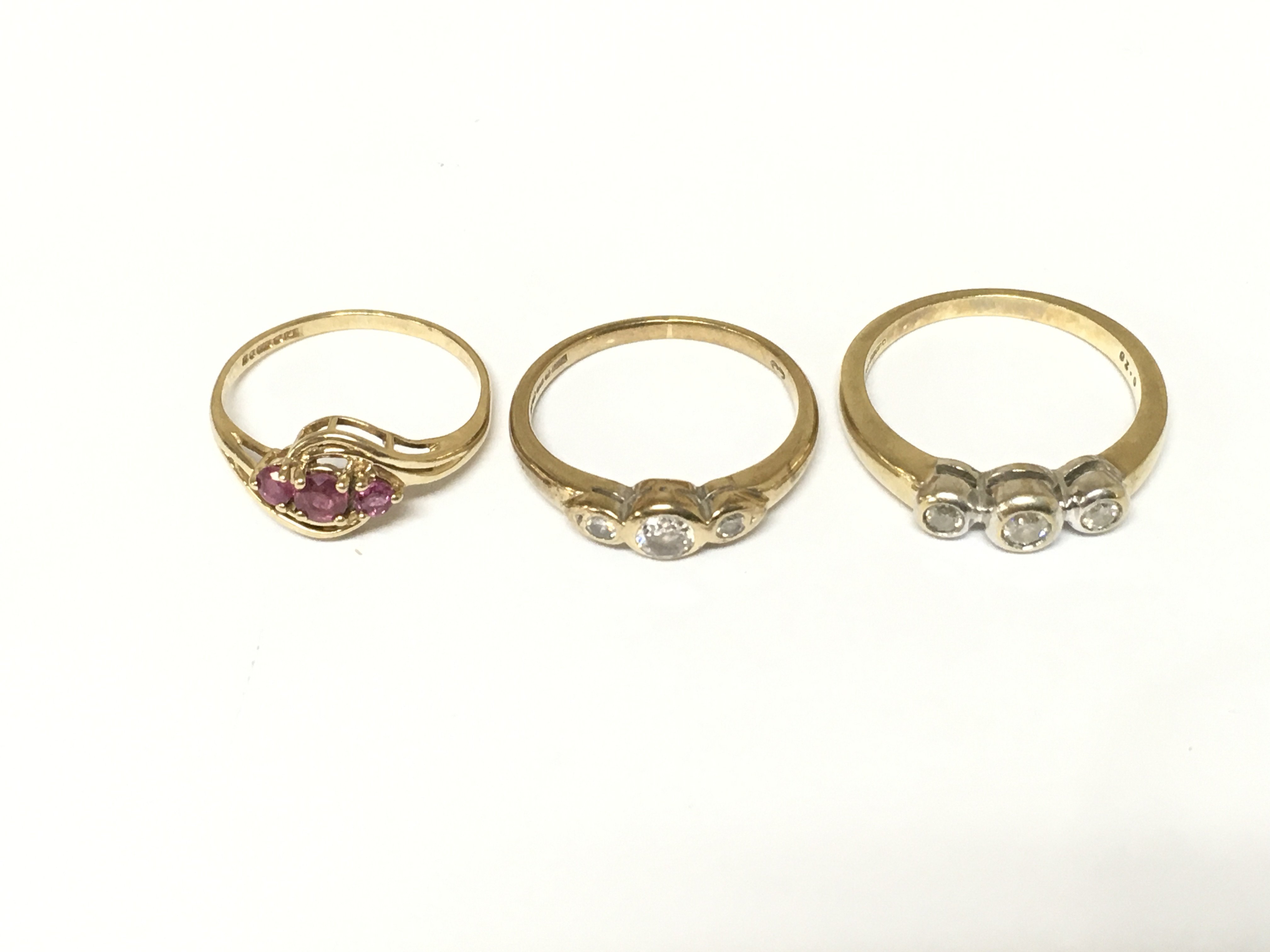 Two 9ct gold rings set with three diamonds and one 9ct gold ring set with 3 rubys. Approximately 5.5g and Sizes K L and N