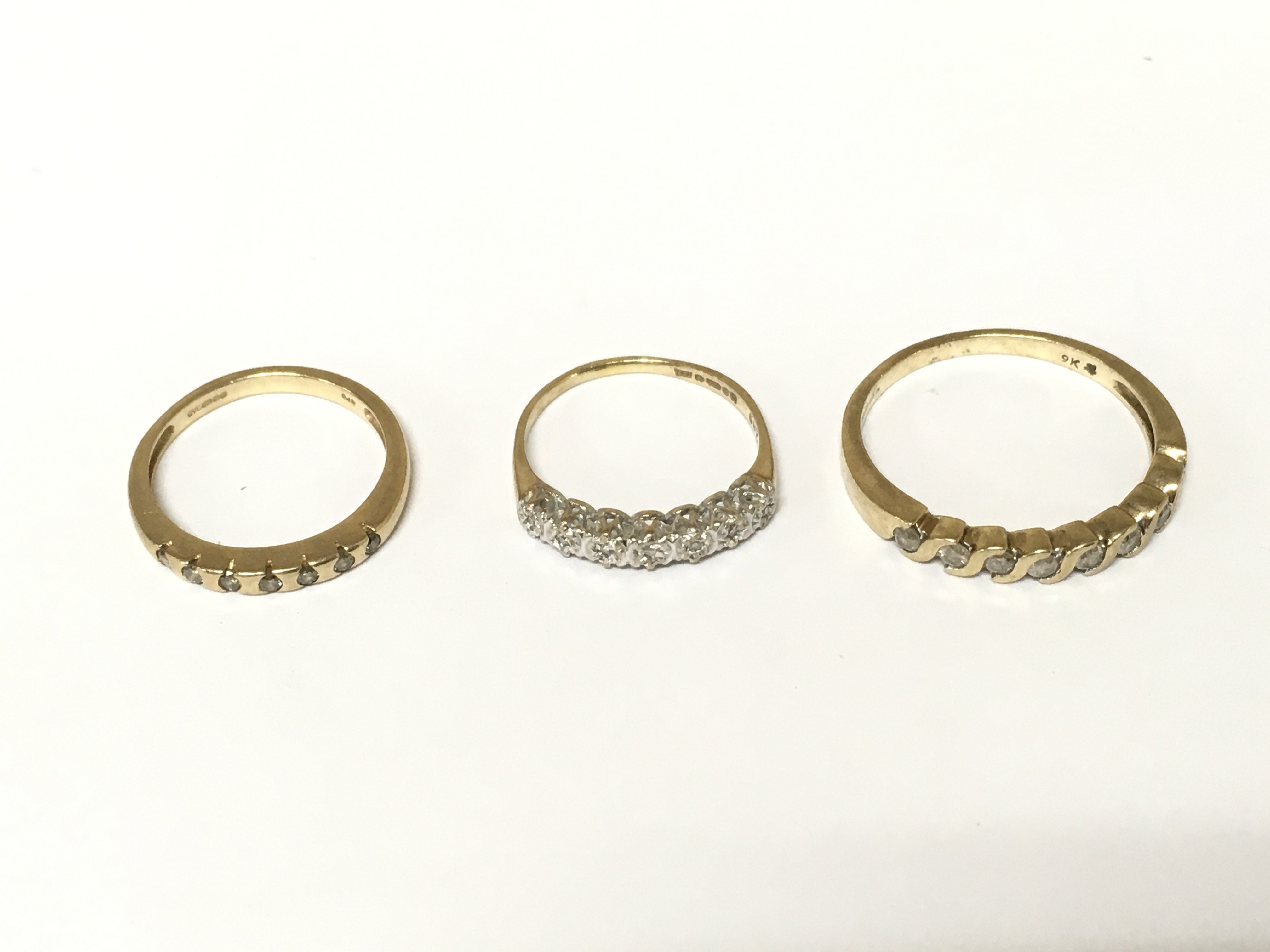 Two 9ct gold diamond half hoop rings and 1 9ct gold ring with white stones. Approximately 5.5 g and sizes K and S