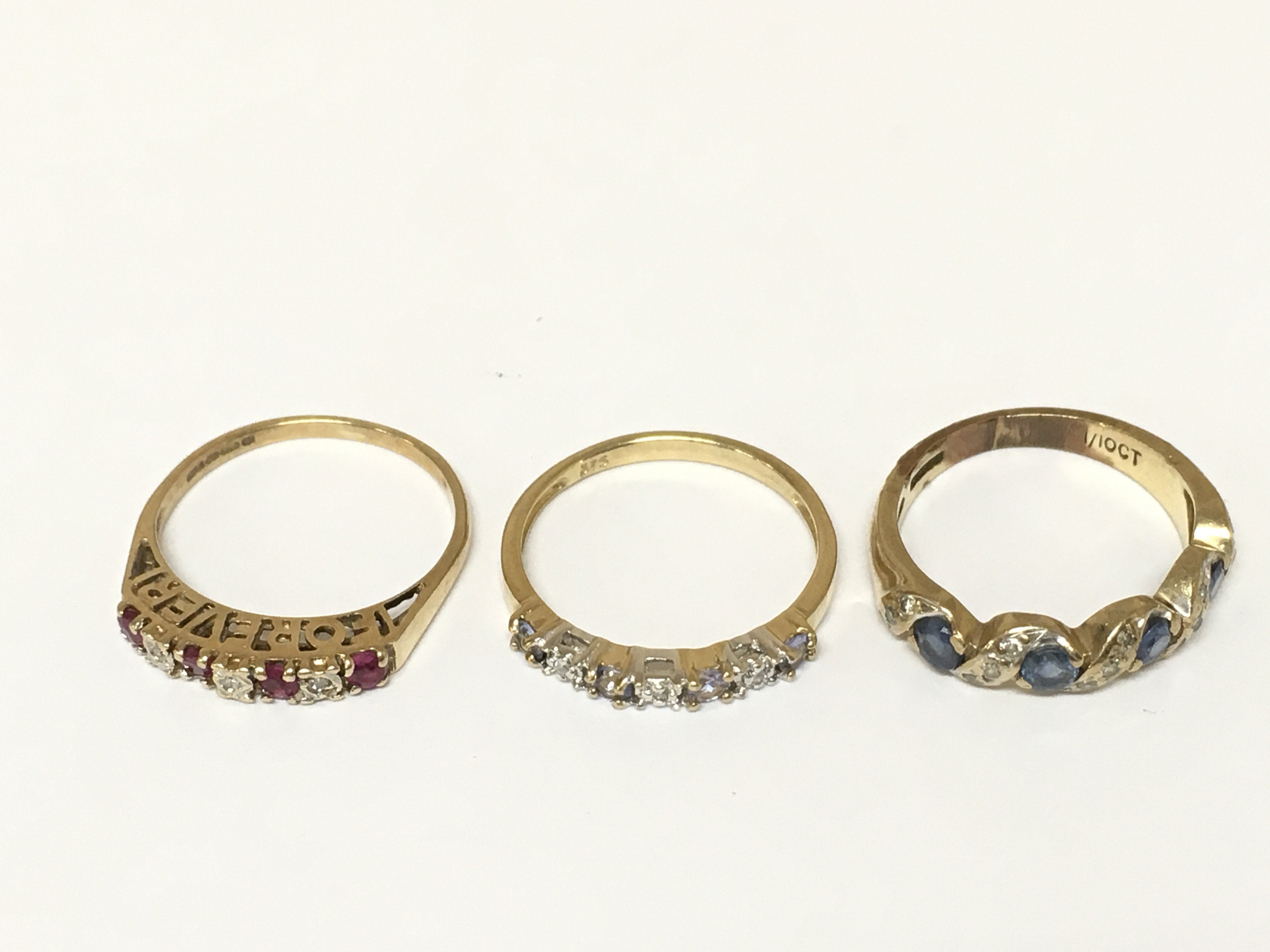Three 9ct gold rings set with various gems including diamonds. Approximately 5.1g sizes K and K 1/2