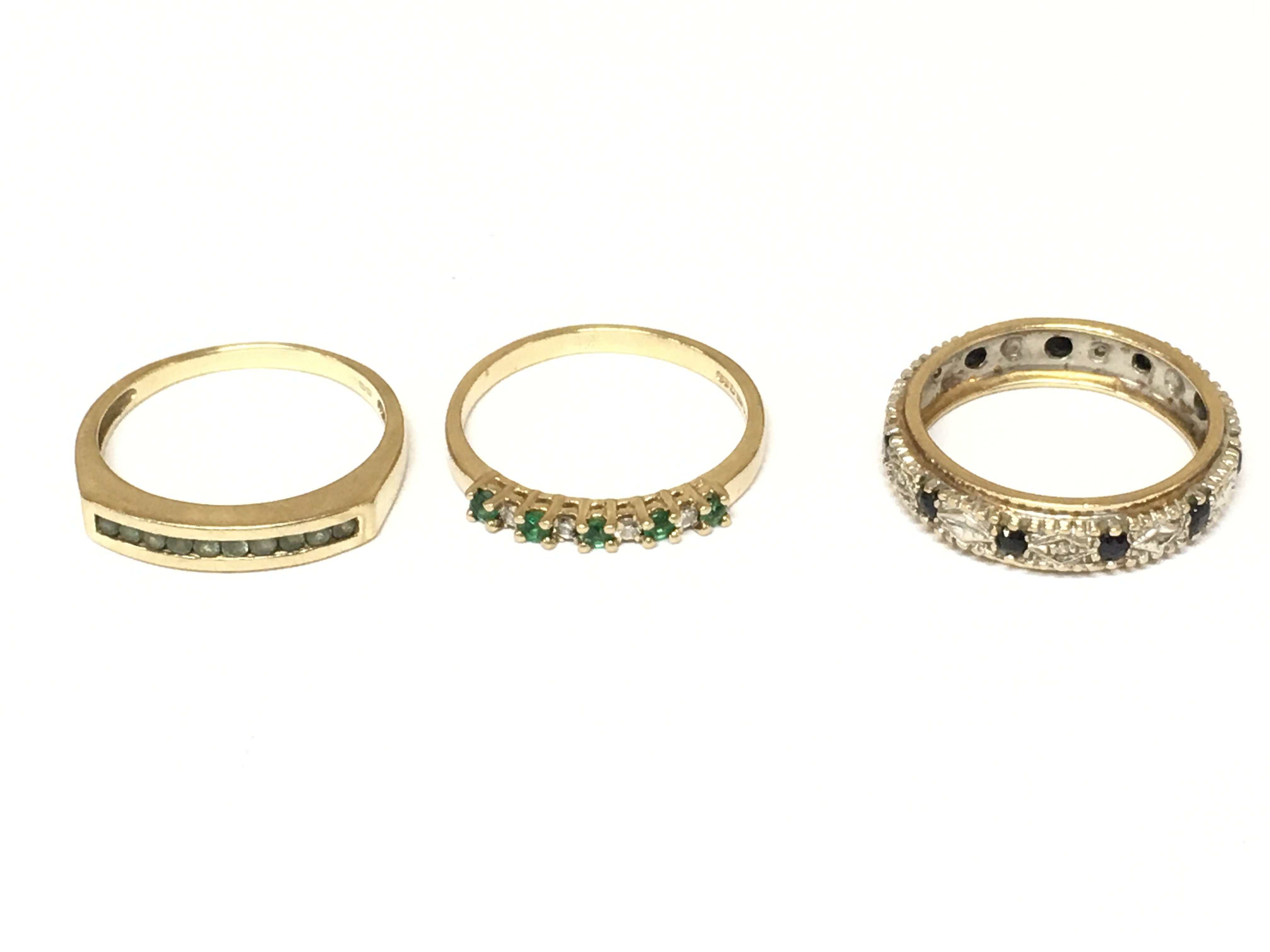 Three 9ct gold rings set with various stones including a full eternity ring. Approximately 6.4g sizes M and N
