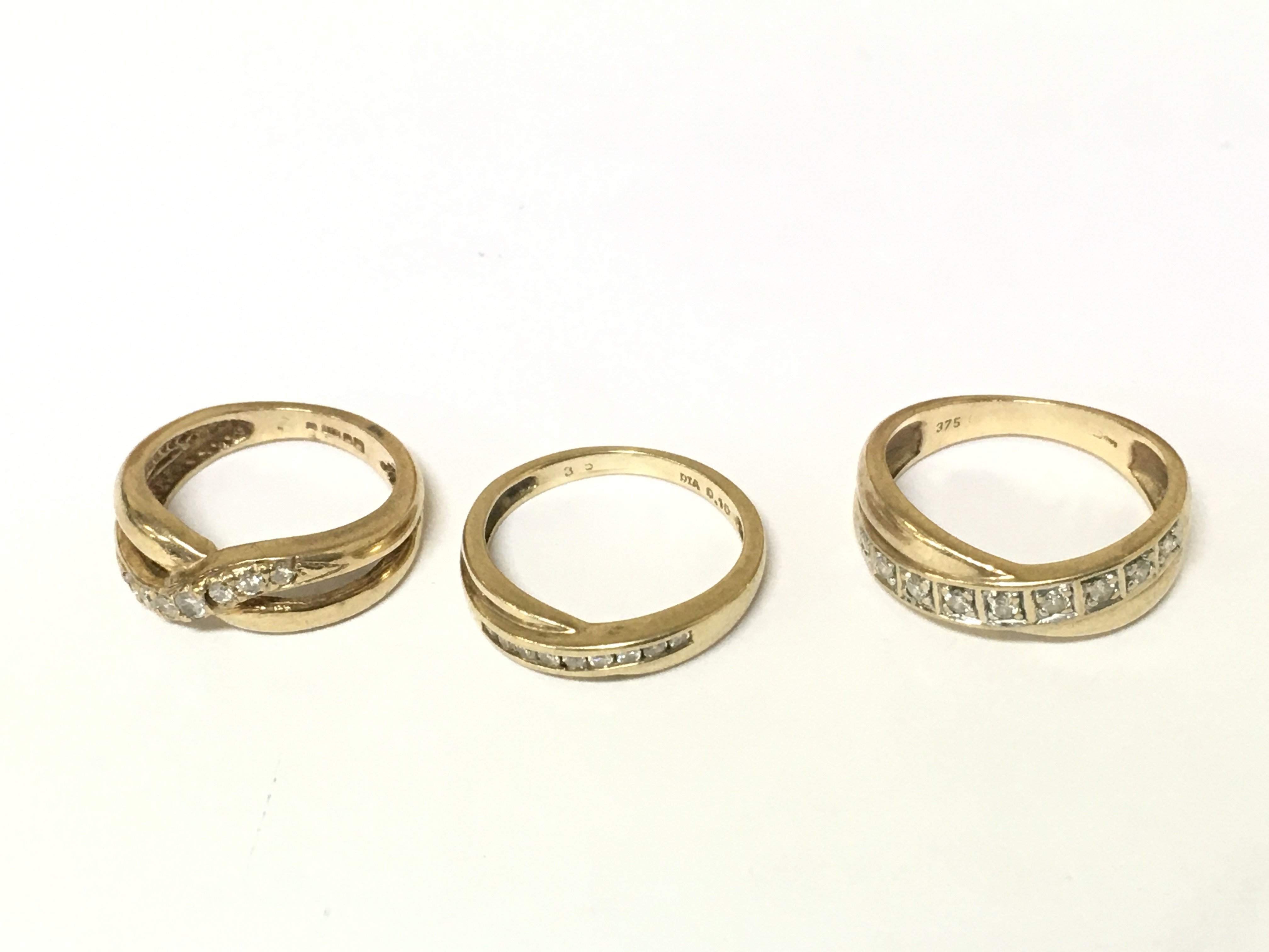 Three 9ct gold crossover diamond rings. Approximately 5.8g sizes E G and K