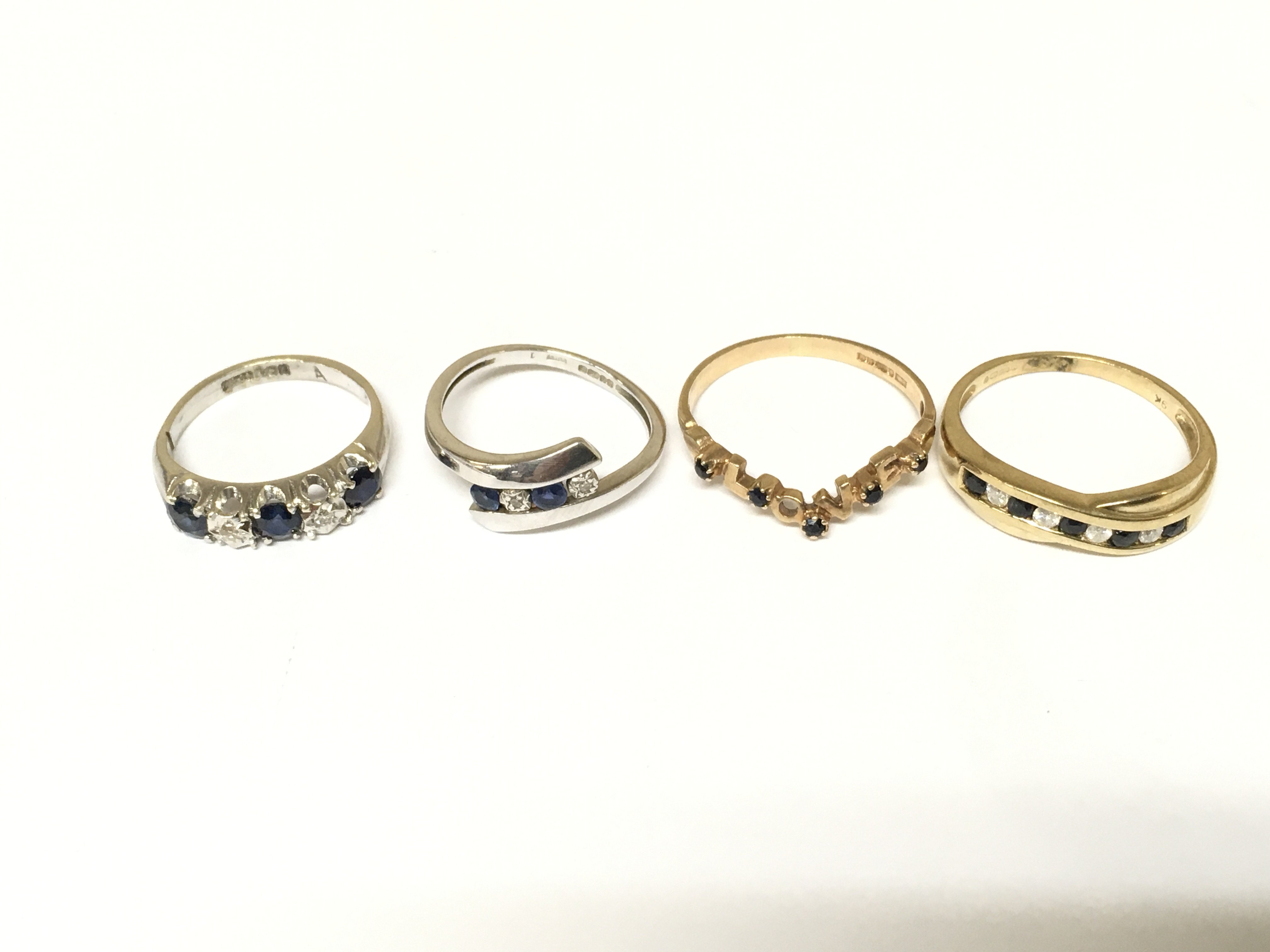 4 rings set with diamonds and sapphires three marked 9ct gold. Total weight approximately 7.1g. Sizes I K O P