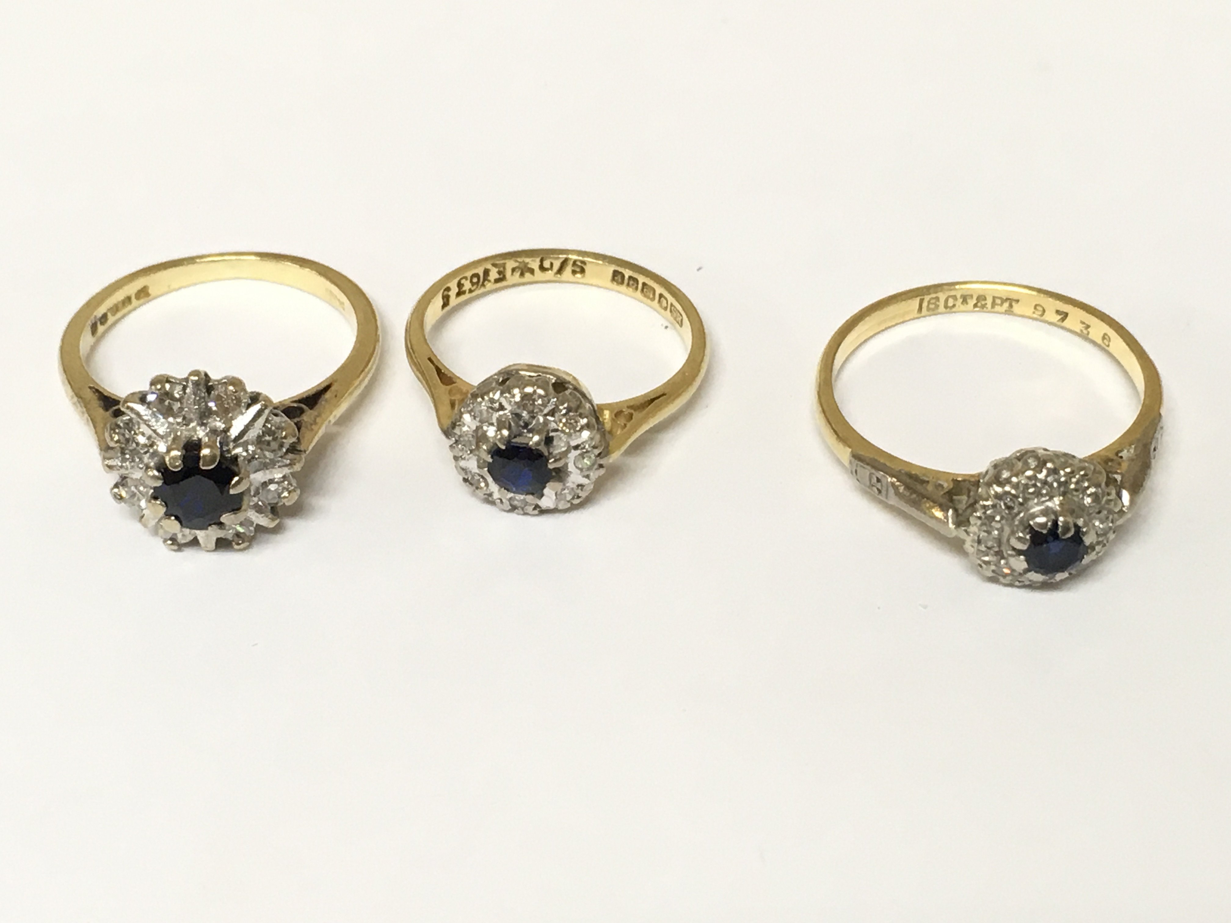 Three 18ct gold diamond and sapphire cluster rings. Approximately 10g sizes H and N