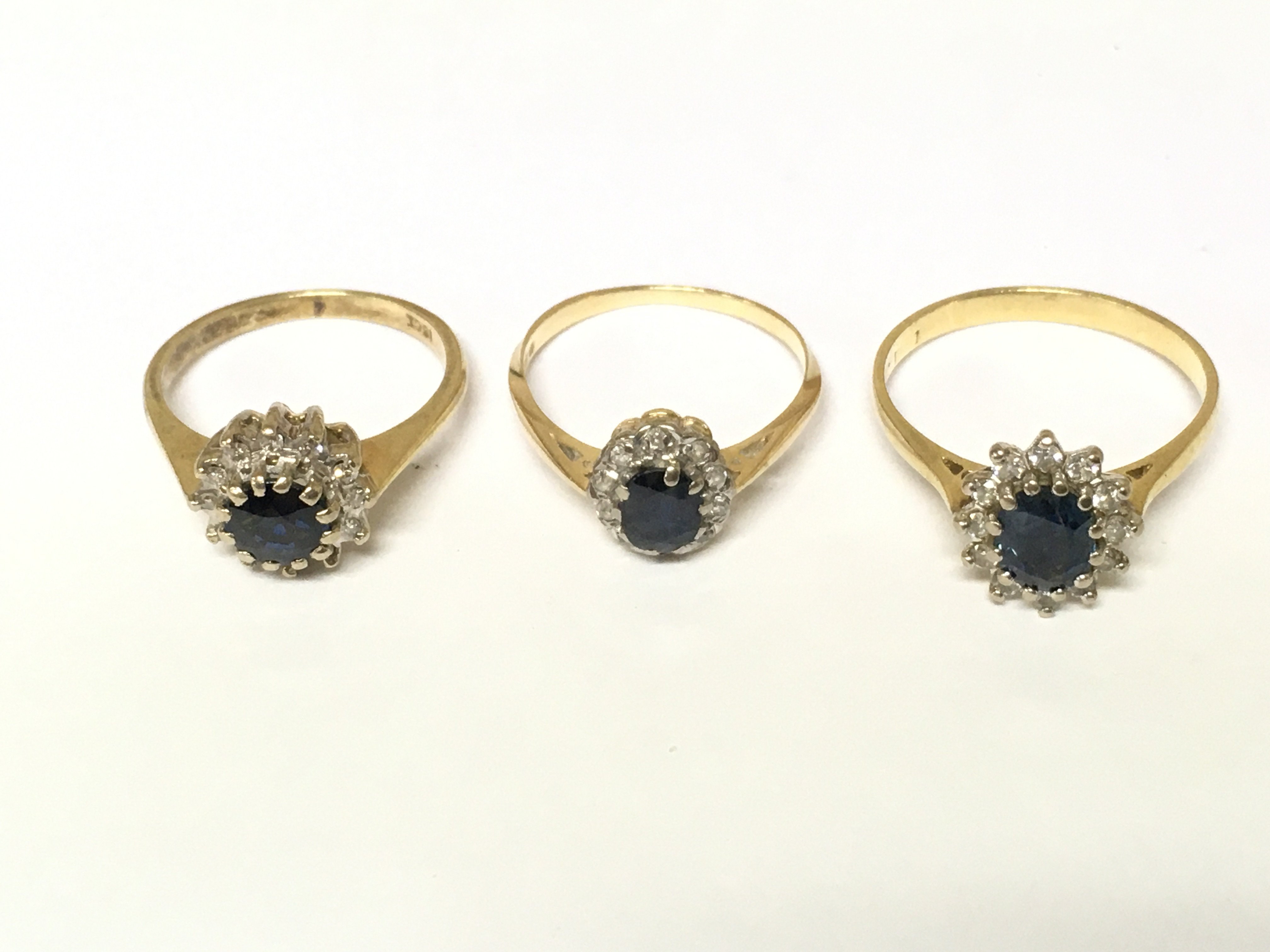 Three 18ct gold diamond and sapphire cluster rings. Approximately 9g and sizes L M and Q