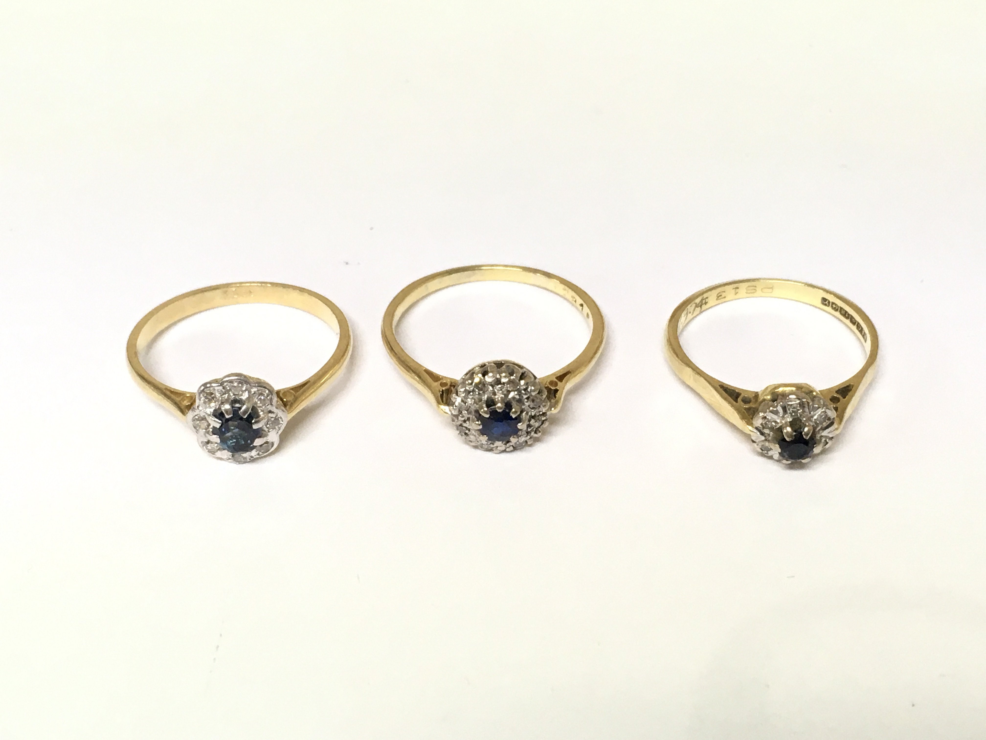 Three 18ct gold diamond and sapphire cluster rings. Approximately 8.4g sizes M O P