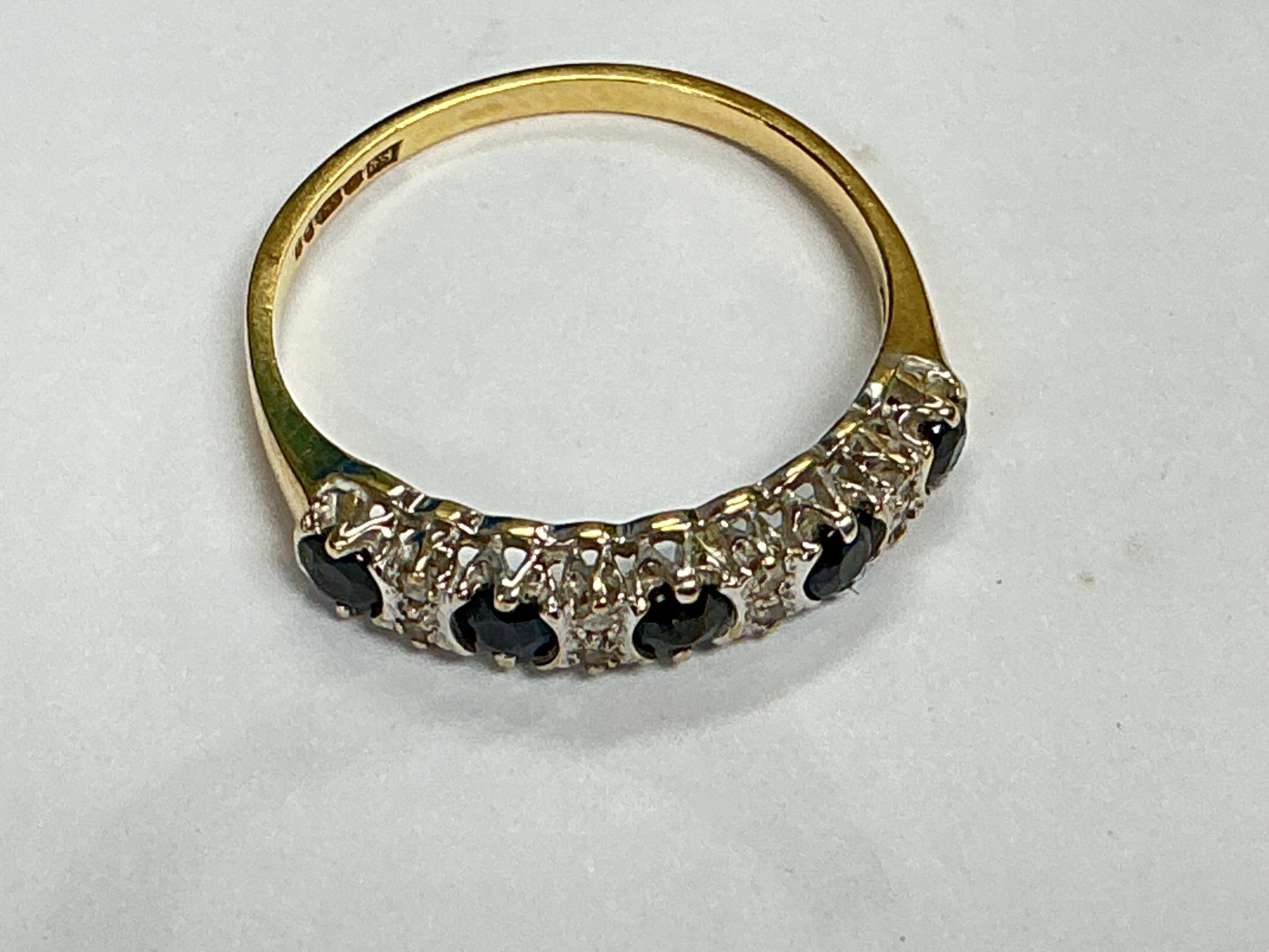 a 9ct gold ring with row set sapphires and small diamonds. Approx weight 1.50 grams, approx size M.