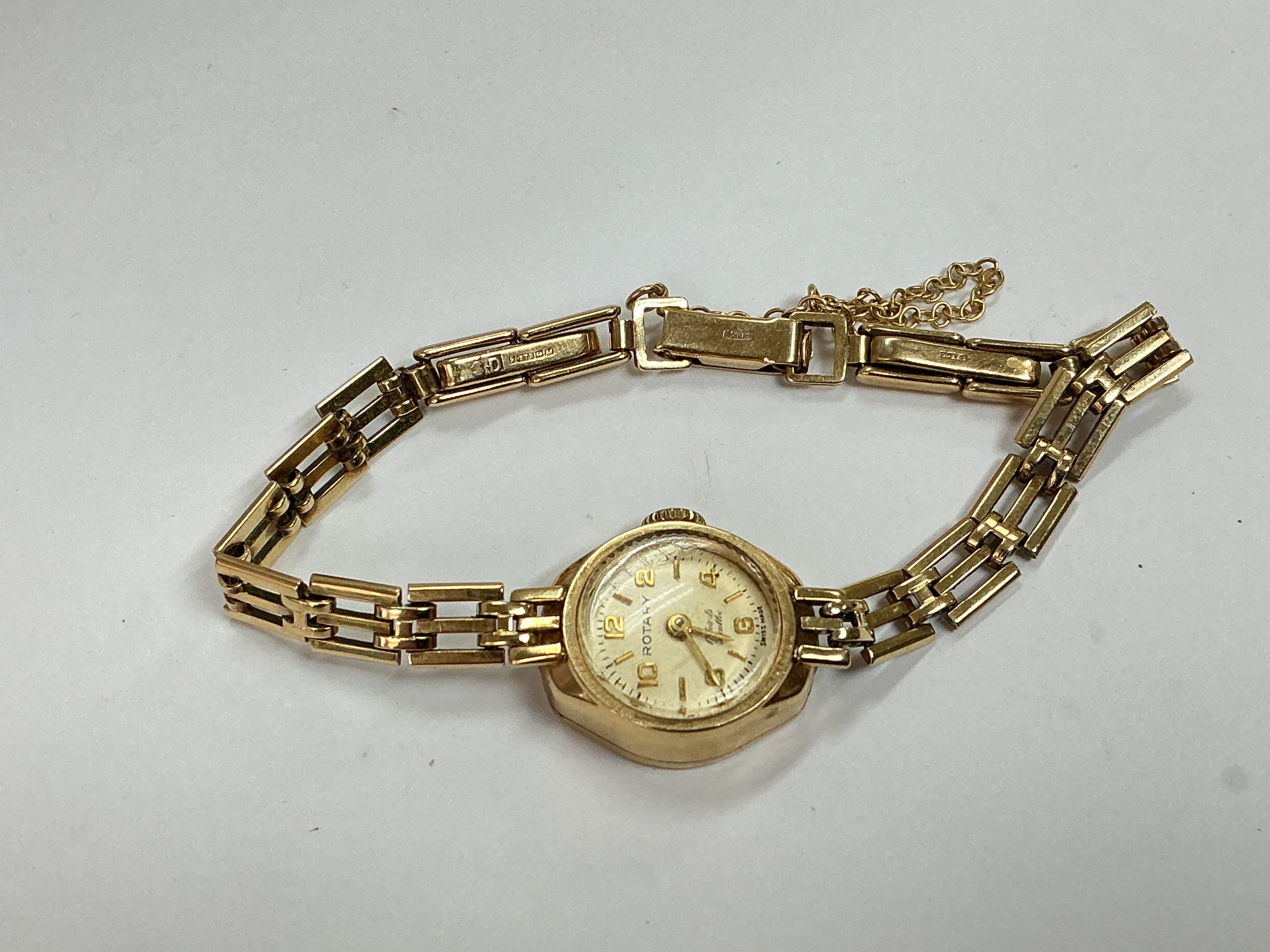 a 9ct gold ladies rotary watch with safety chain, approx weight without movement 9.25 grams.