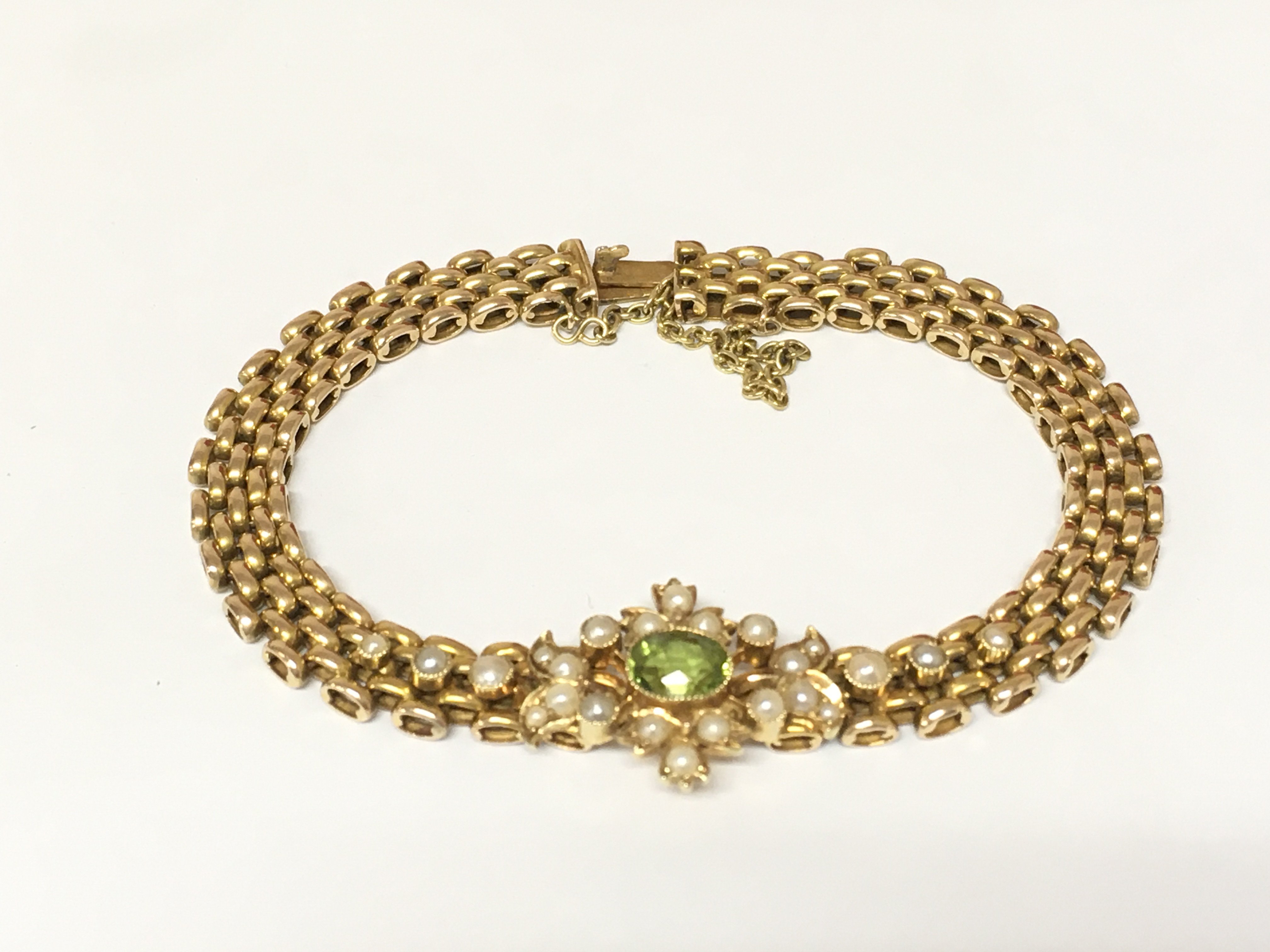 An Edwardian 15ct gold seed pearl and peridot bracelet. 16.40g