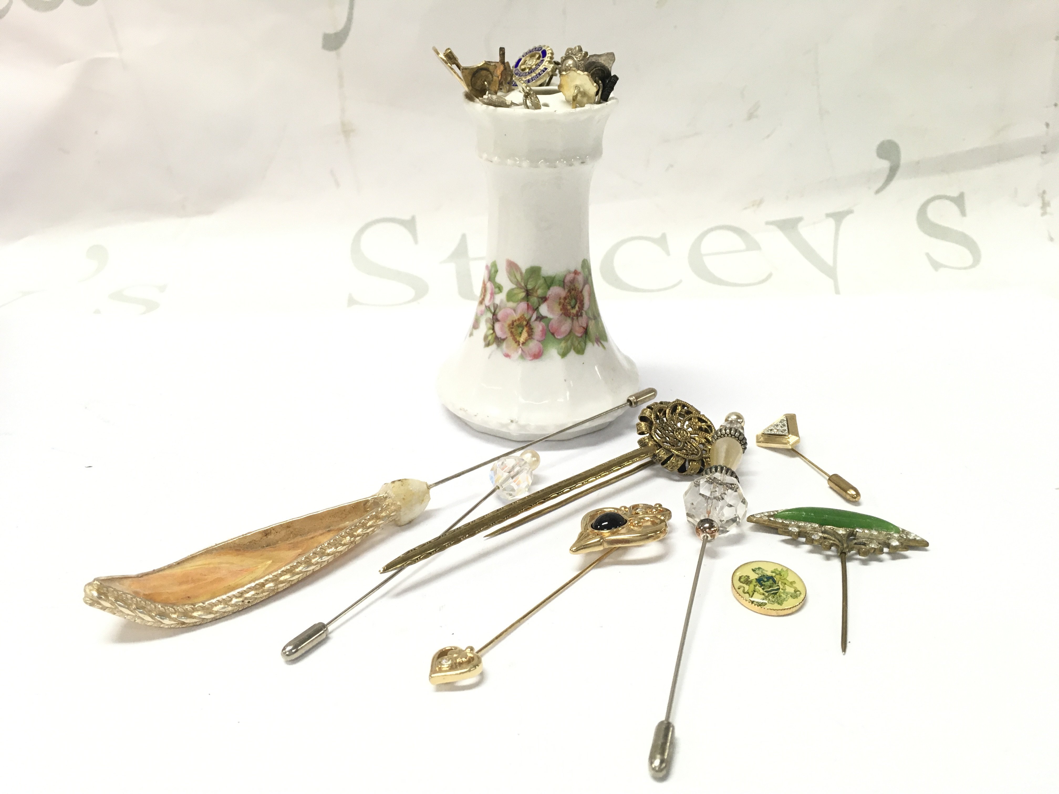 Stick pins , some silver . on stand . Approximately 20 pins . This lot cannot be posted