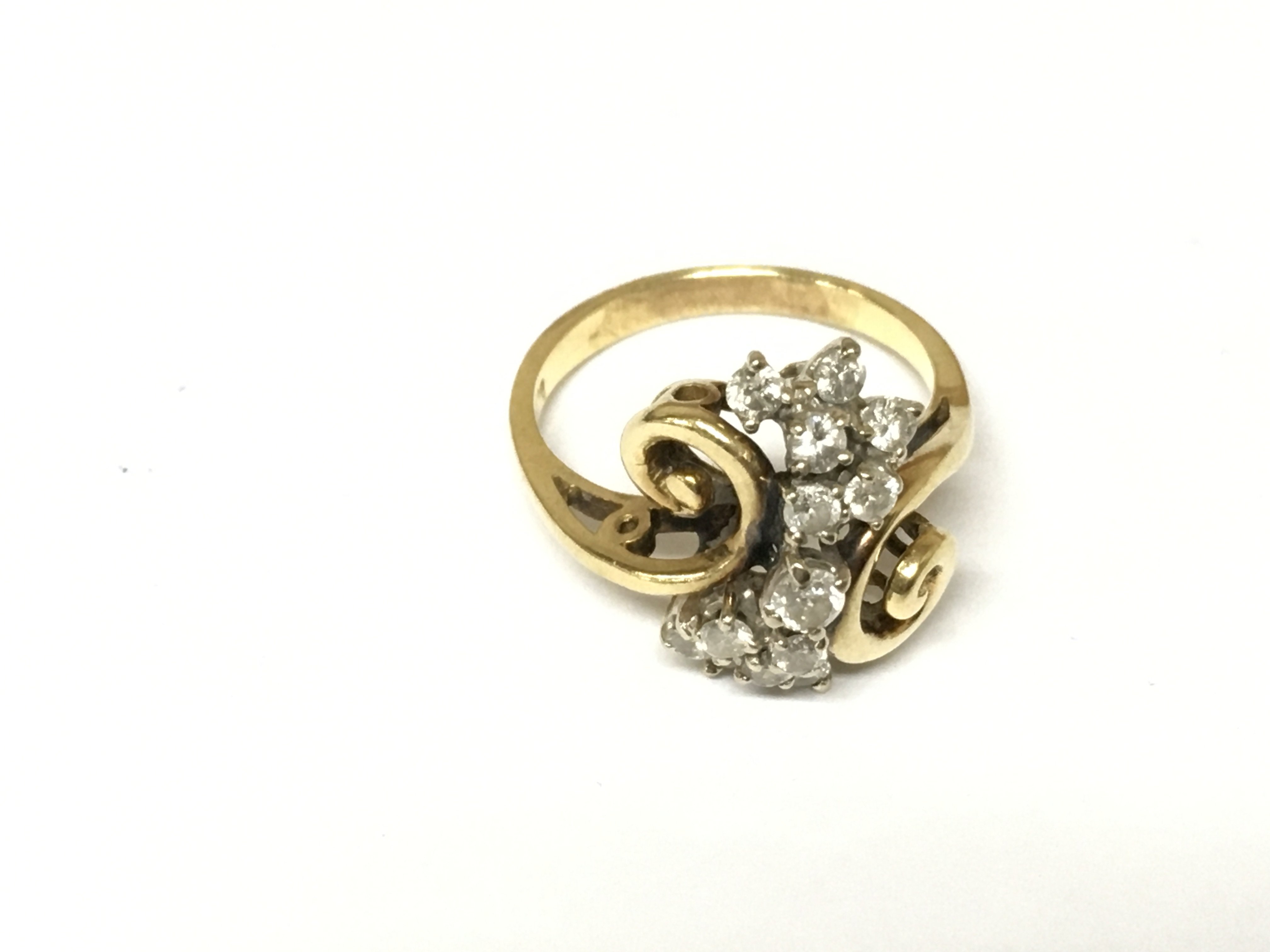 An 18ct gold diamond swirl cluster ring. Approximately 5.3g and size O
