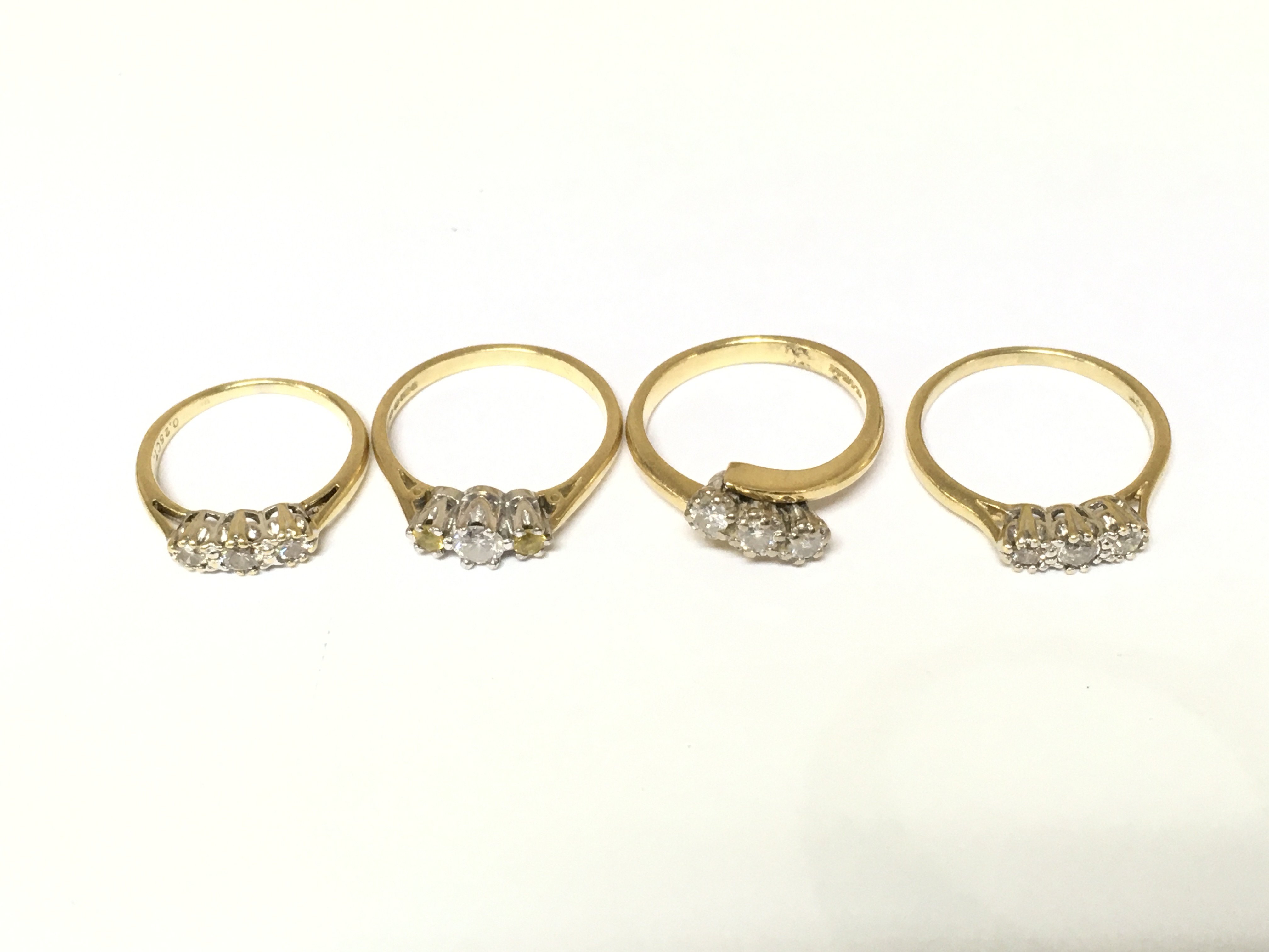 Four 18ct gold 3 stone diamond rings. Approximately 11.5g and sizes H M and N