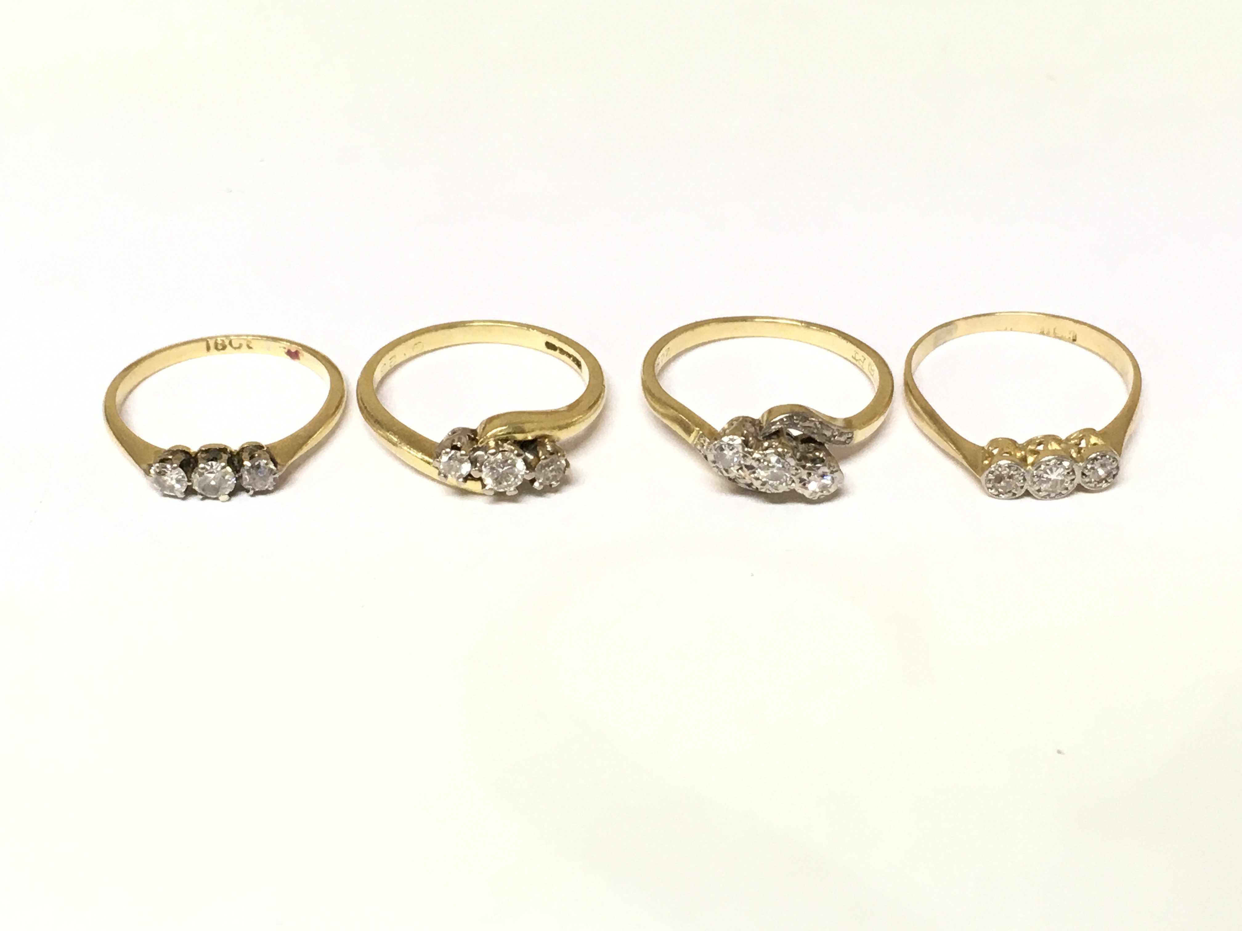 Four 18ct gold 3 stone diamond rings. Approximately 9.7g sizes J M and N