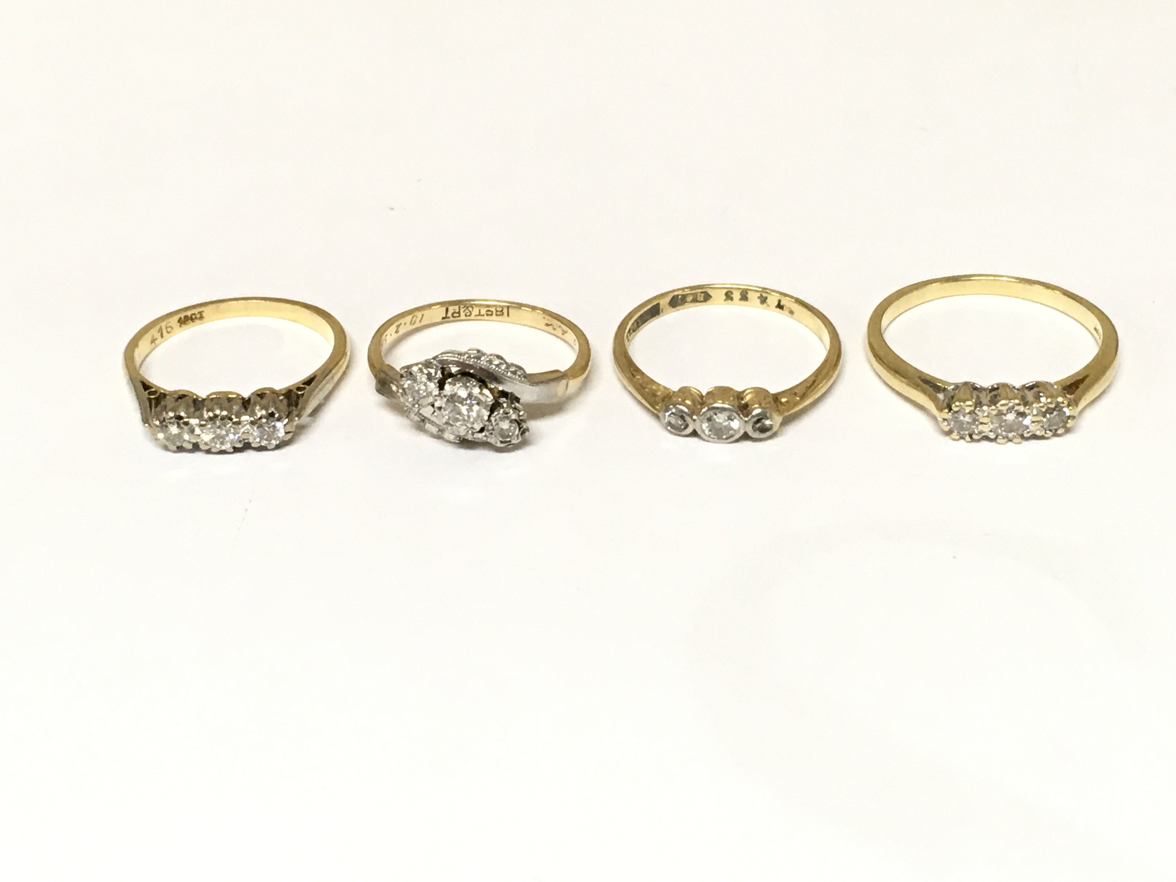 Four 18ct gold 3 stone diamond rings. Approximately 10.2g and sizes K M and O