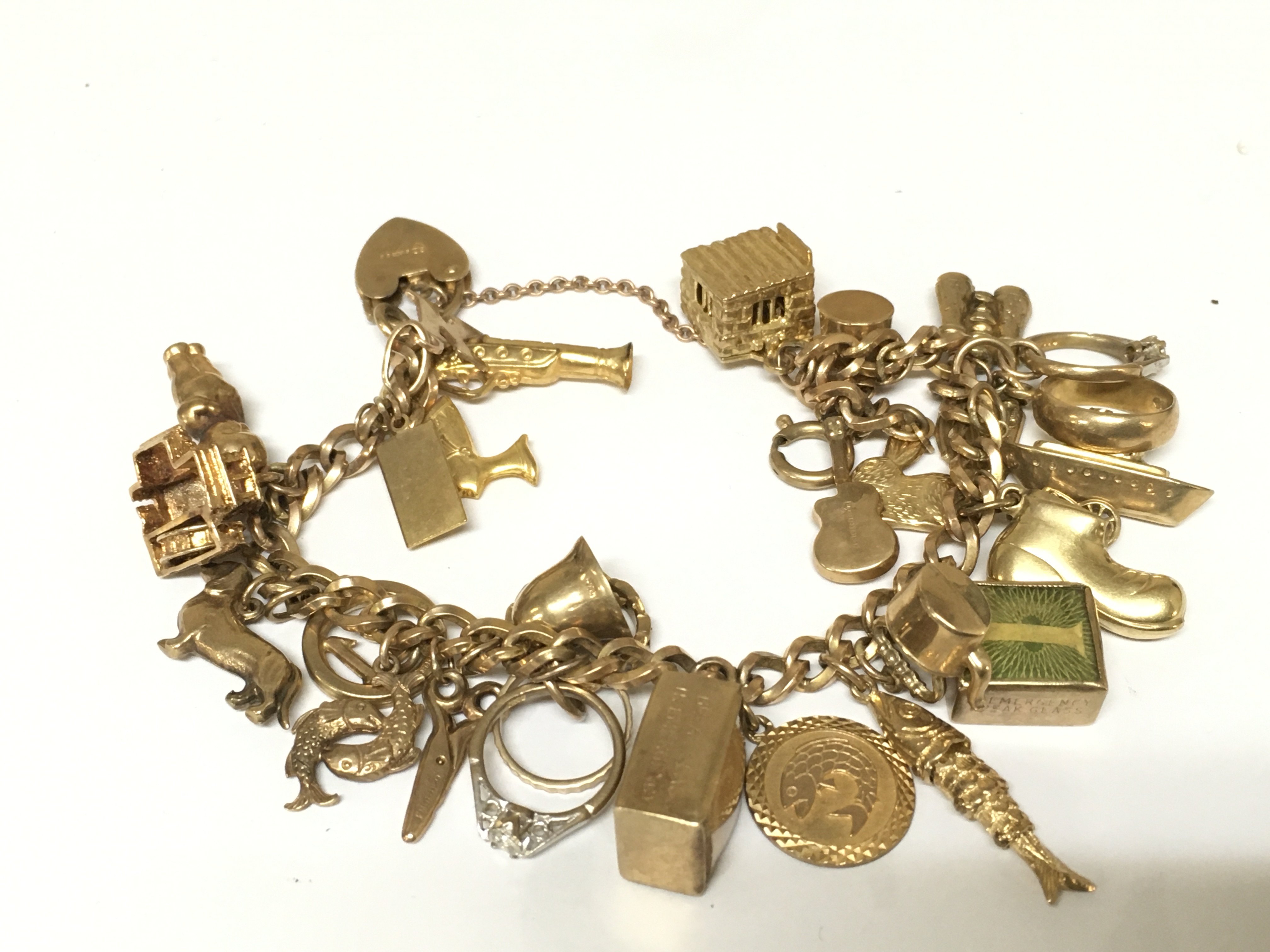 A 9ct gold charm bracelet set with assorted charms. 51g