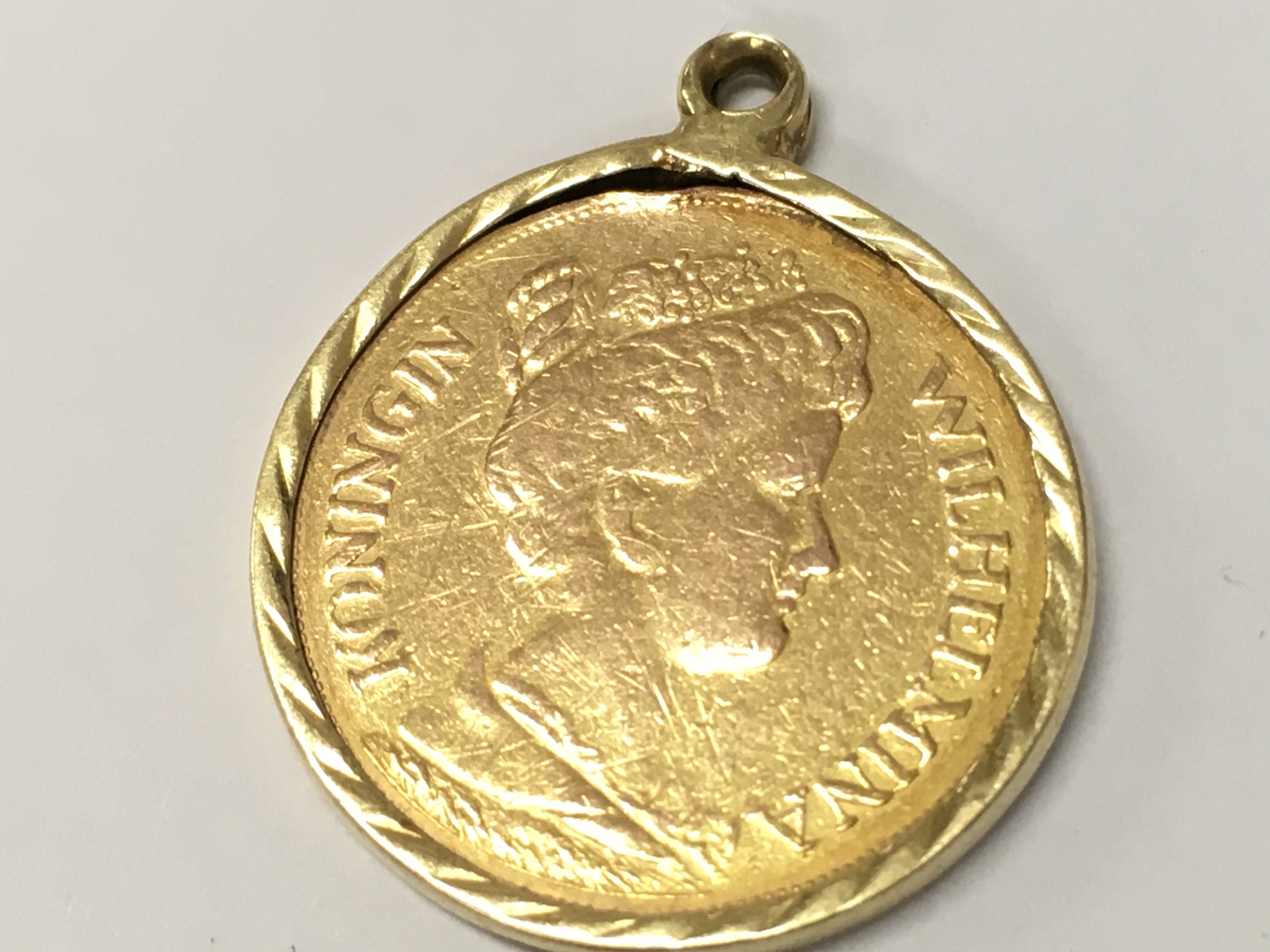 A 1912 Netherlands 5 Gulden Gold Coin in a mount, total weight 3.6g . Postage category A