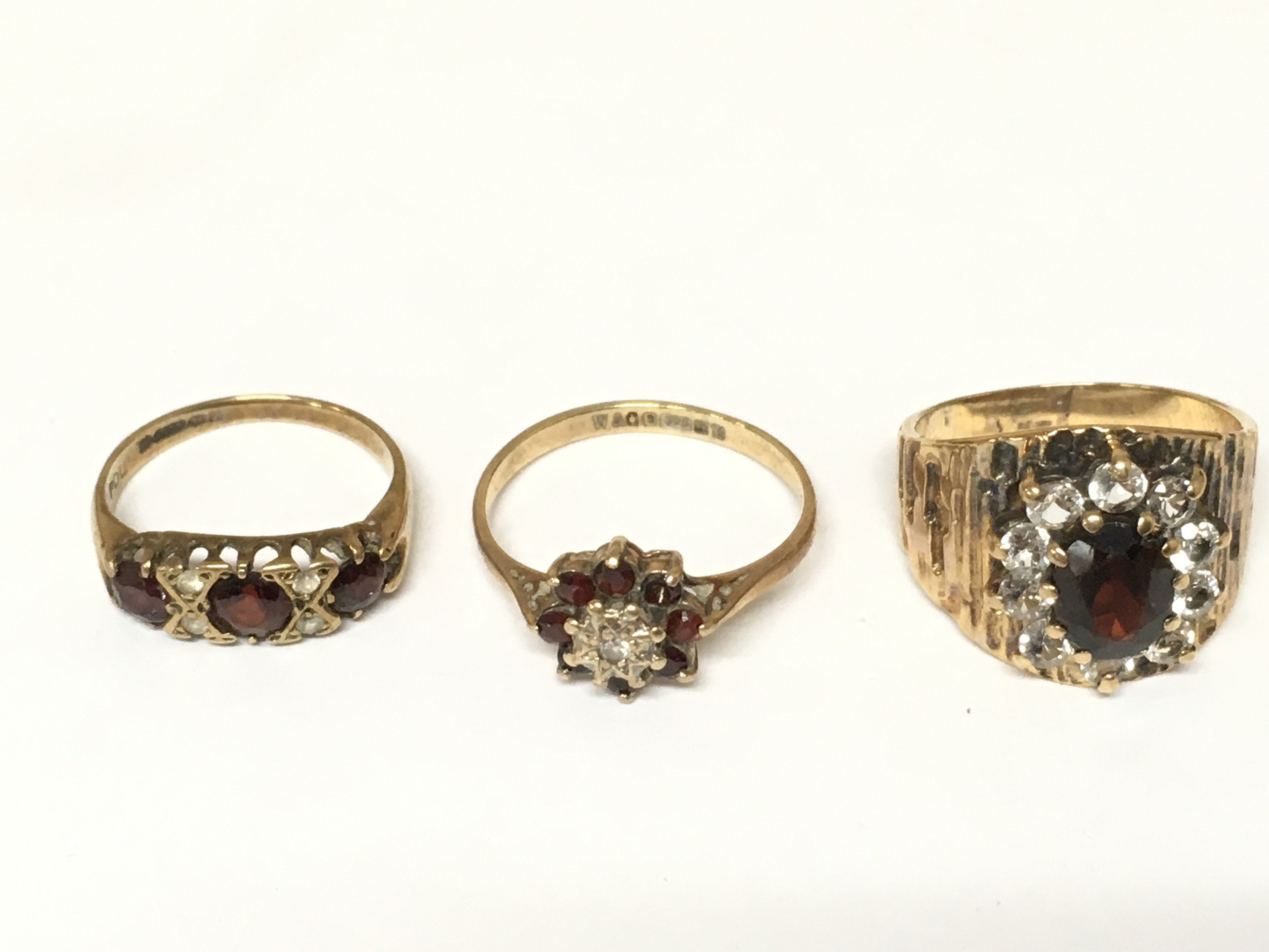 Three 9ct gold rings set with assorted gems. Approximately 8.53g and sizes I M and M 1/2