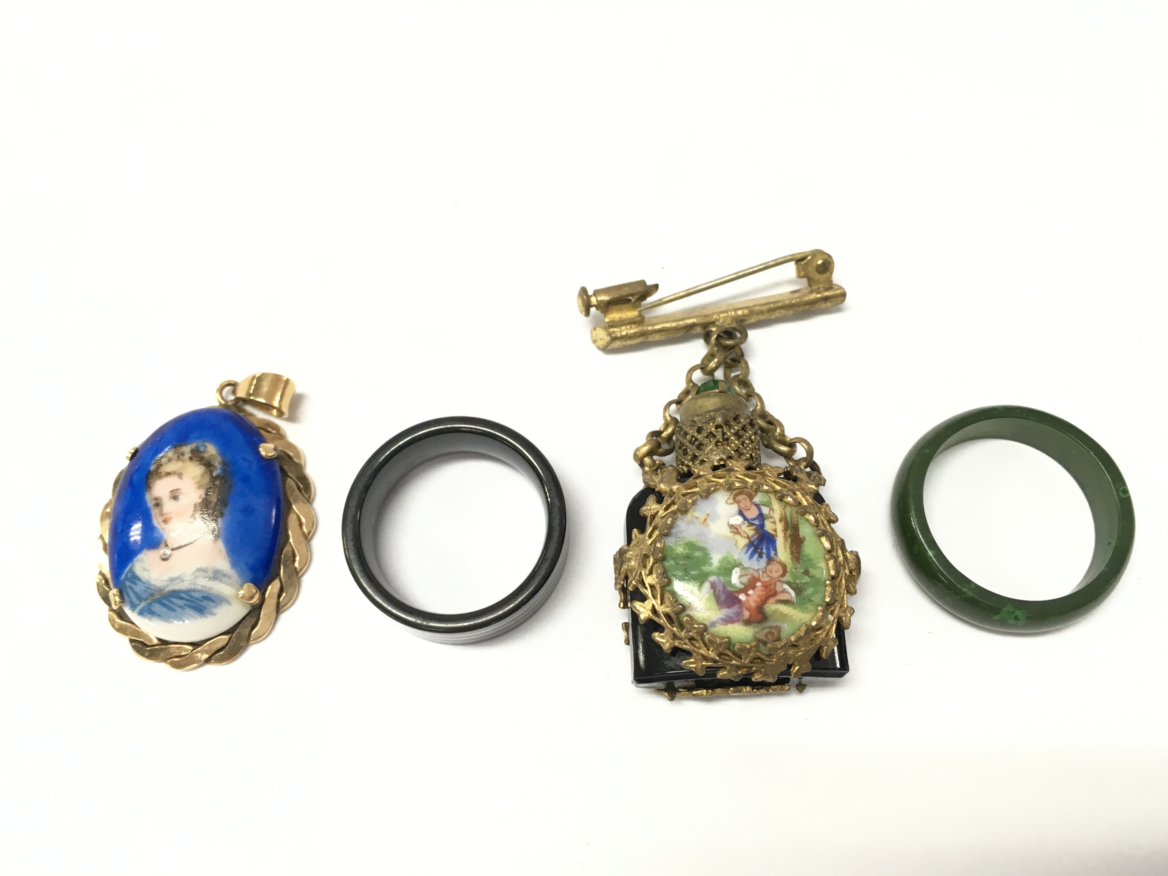 A perfume bottle brooch, two rings and a pendant. Postage category A