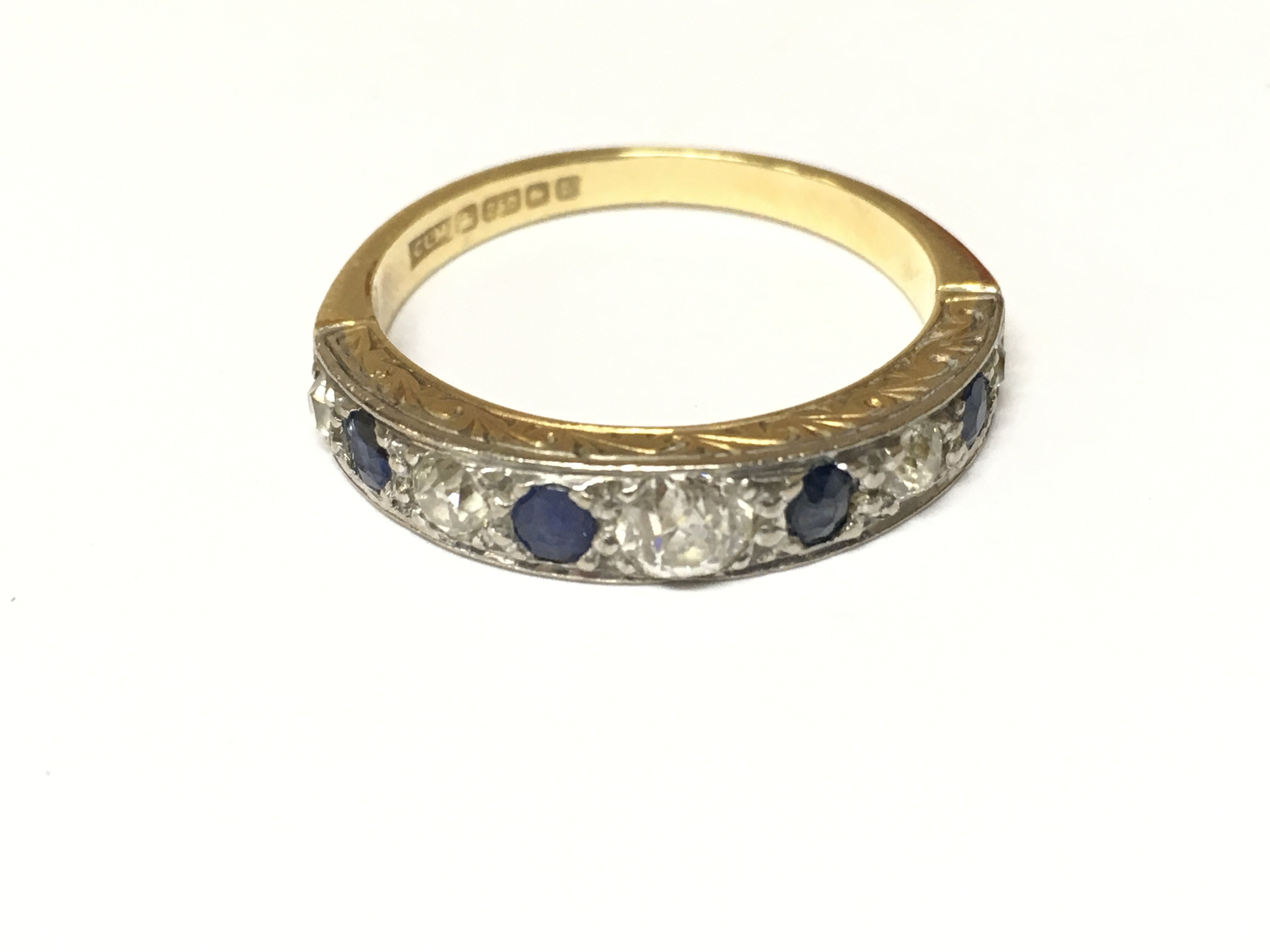 An 18ct sapphire and diamond 9 stone half eternity ring. Approximately Size R and 4.30g